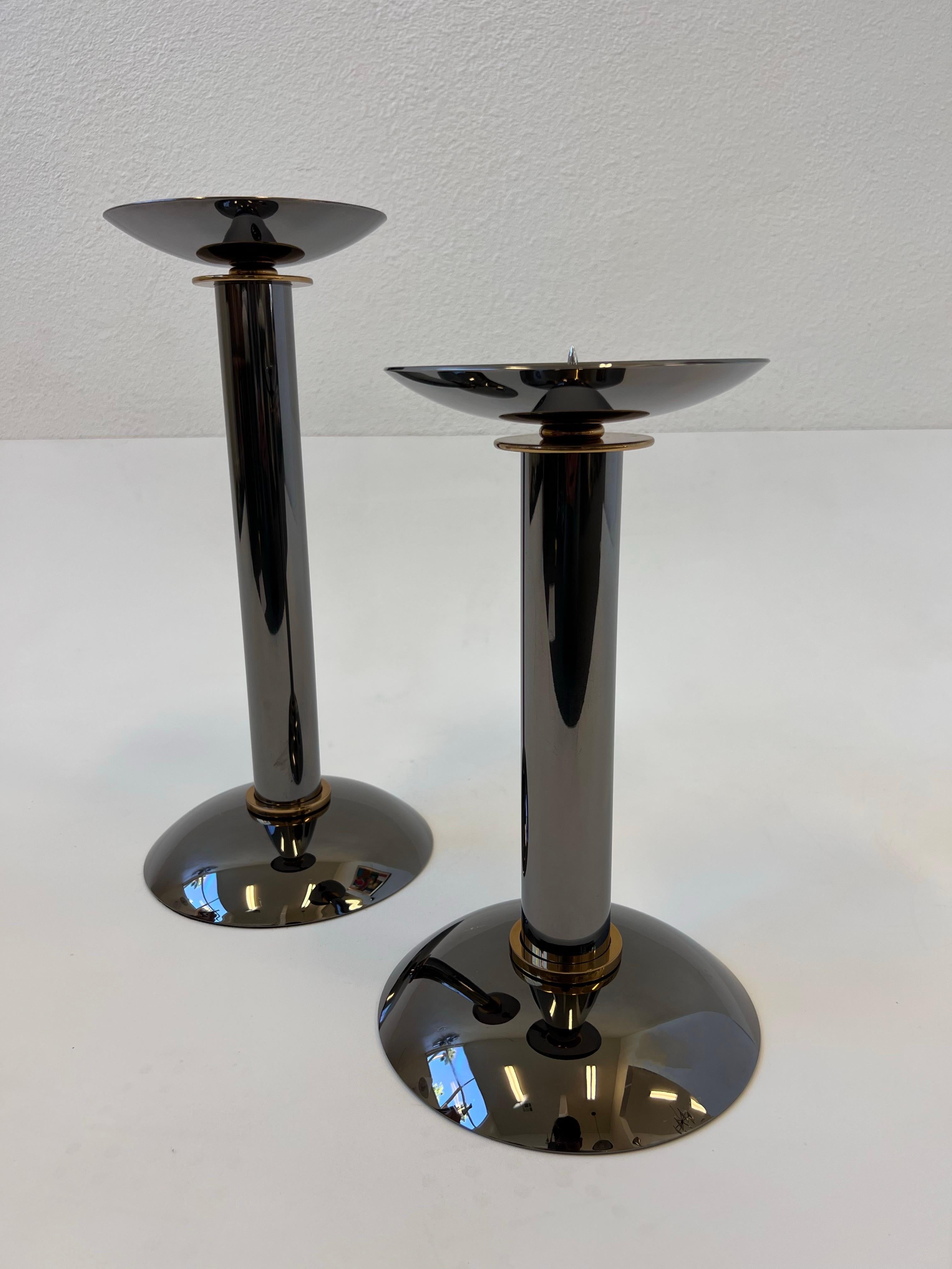 1980’s Large Pair of polis gunmetal and brass candleholders by Karl Springer. 
In beautiful vintage condition. 
We also have a set of three in a different listing, shown in last photo. 

Dim: 
Large-16” High, 7.5” Diameter.
Small-12.75” High, 7.5”