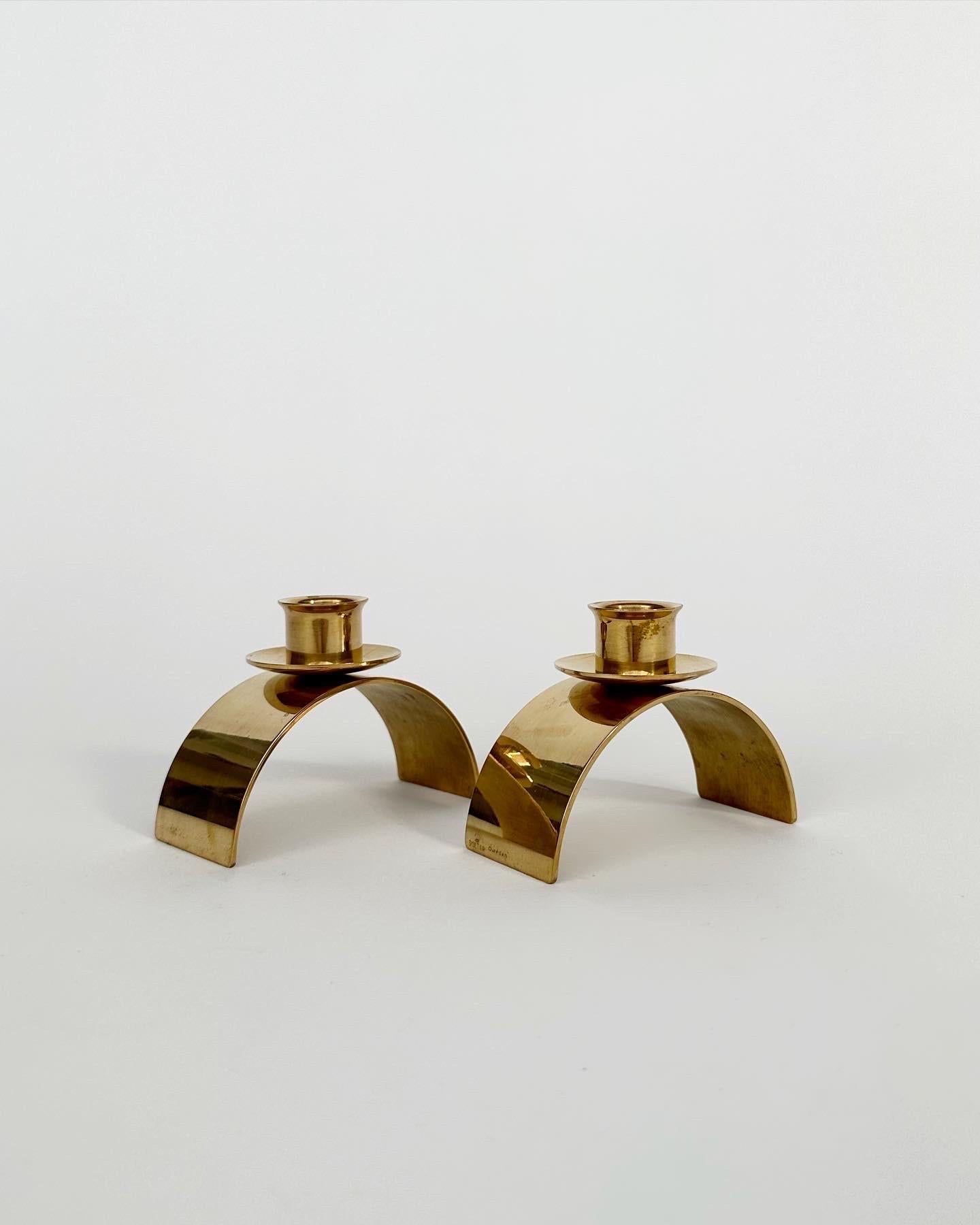 Pair of rare Gunnar Ander „Valvet“ candle sticks in solid brass, made by Skultuna in Sweden in 1995.

Marked with the creators initials, the date and Skultuna logo.

Width: 10 cm
Depth: 4.5 cm
Height: 7.5 cm 
For standard candles with 2 cm.