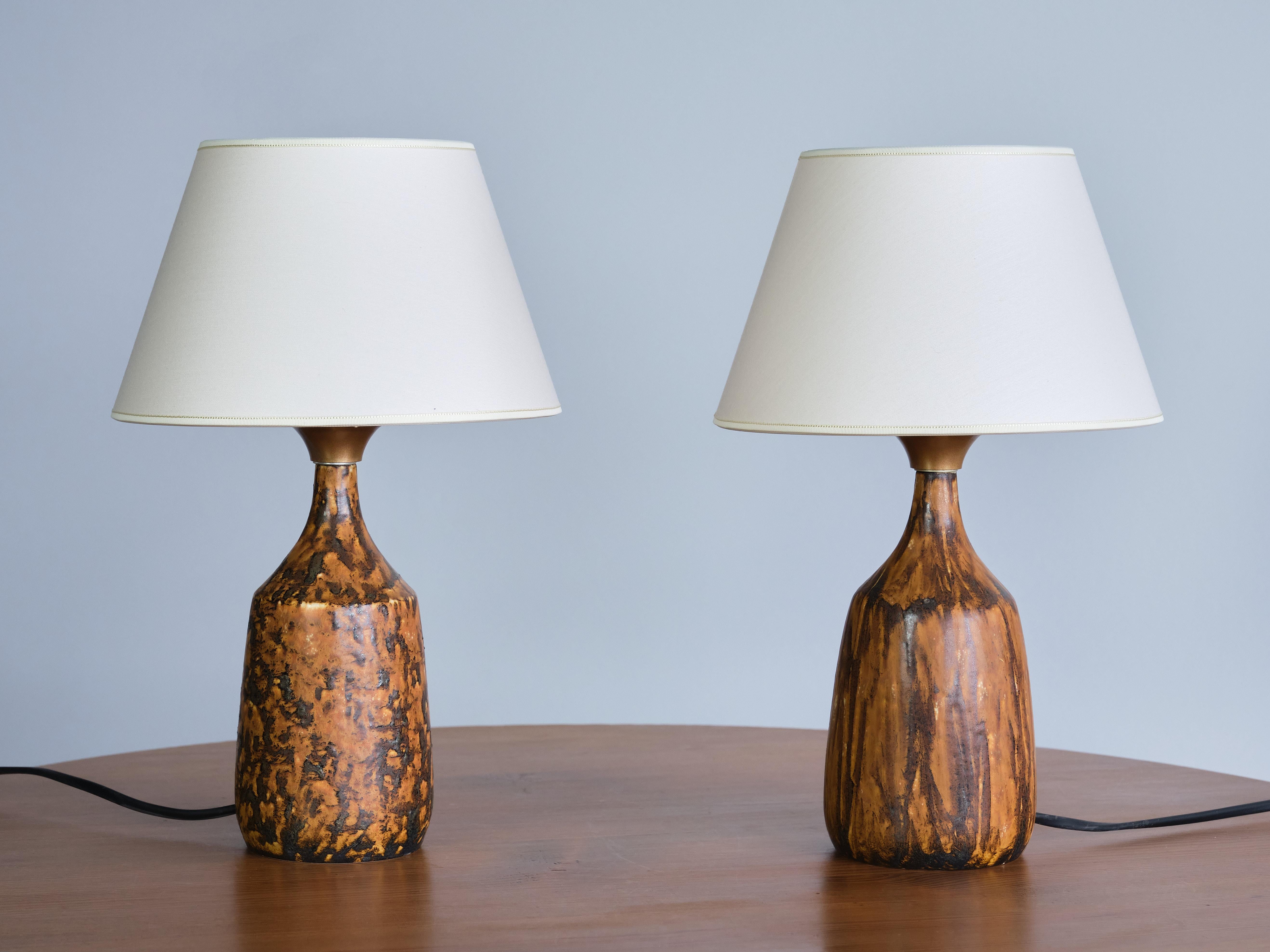 This rare pair of table lamps was designed by Gunnar Borg and produced by his own ceramic workshop 'Gunnars Keramik' in Höganäs, Sweden in the 1960s. The lamps are signed on the bottom of the base.  

The hand-turned stoneware base is made of