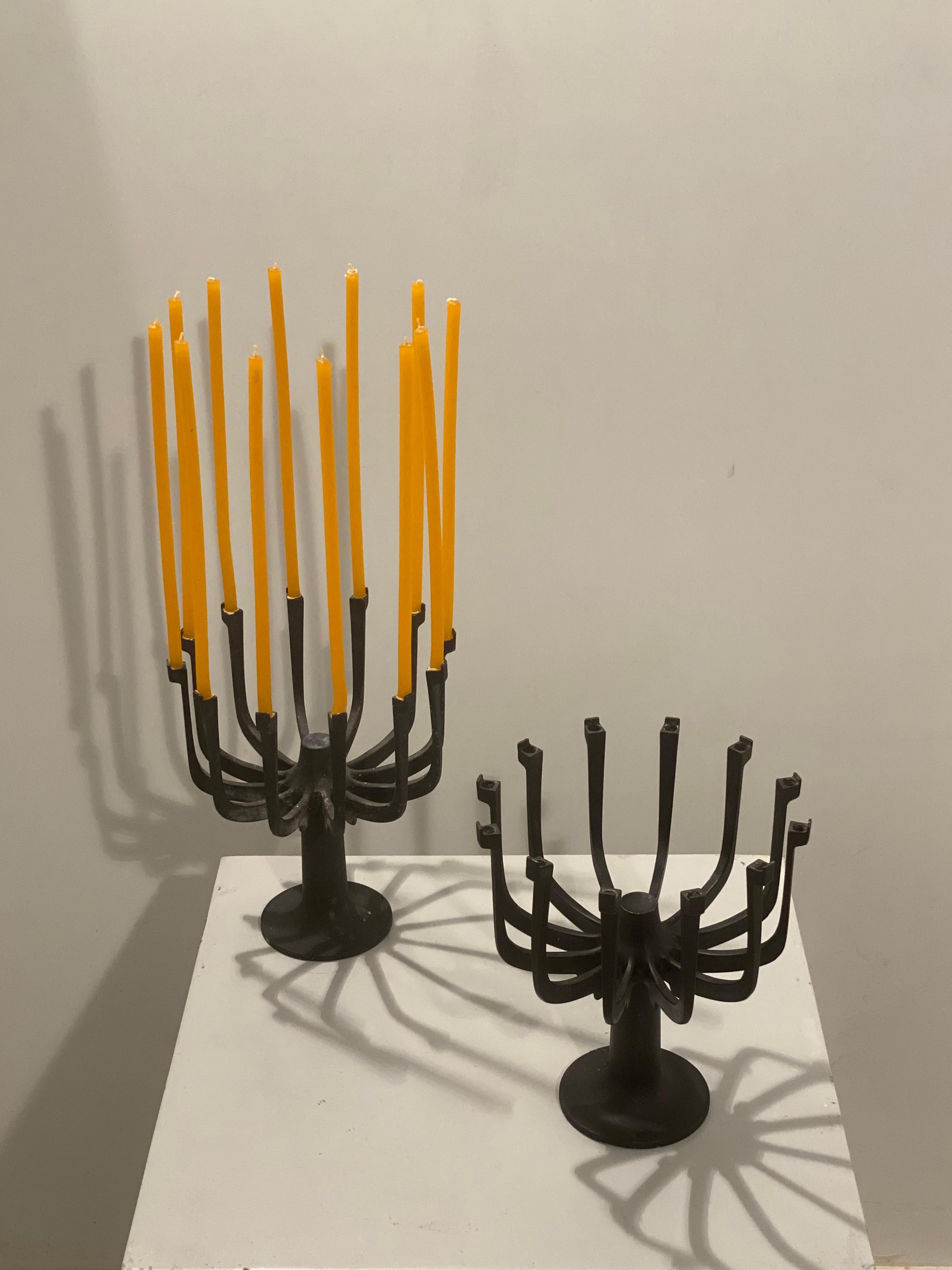 Very elegant pair of Gunnar Cyren for Dansk candle holders made of blackened cast iron. These are very rare pieces, and even more so are the larger 12-candle models. They come with these beautiful slim Romanian hand-crafted candles. Tag engraved