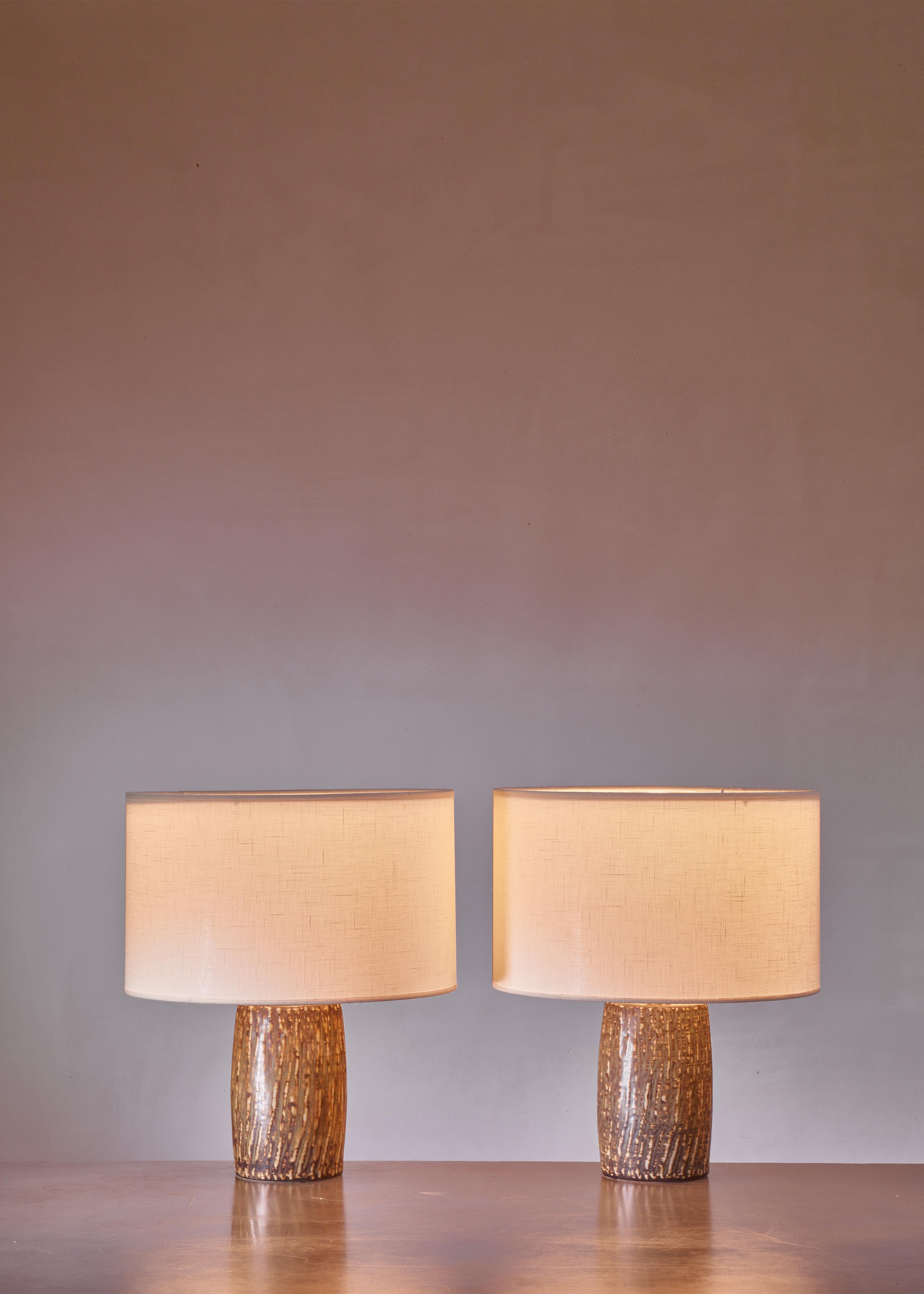 A pair of polychrome ceramic table lamps by Gunnar Nylund for Rörstrand, Sweden. The lamps have a slightly different but matching color pattern in natural earth tones. Marked by Nylund and Rörstrand and in an excellent condition.

The measurements