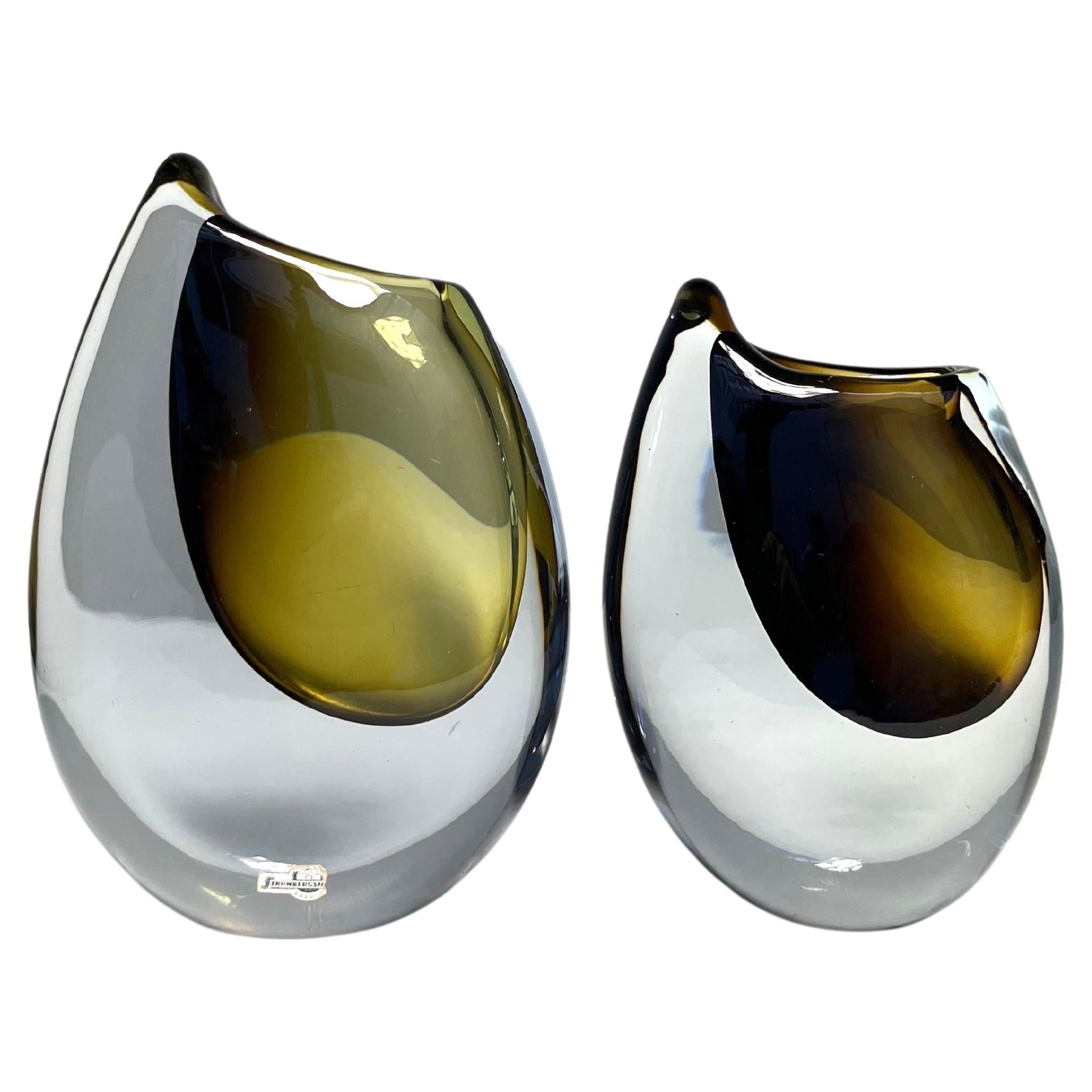 Pair of shark tooth vases designed by Gunnar Nylund in 1957 for Strömbergshyttan, Sweden.

Mouth-blown and hand-shaped glass, larger vase is signed. Both in good condition with a few scratches and microchips, no salt staining inside.

Measures: