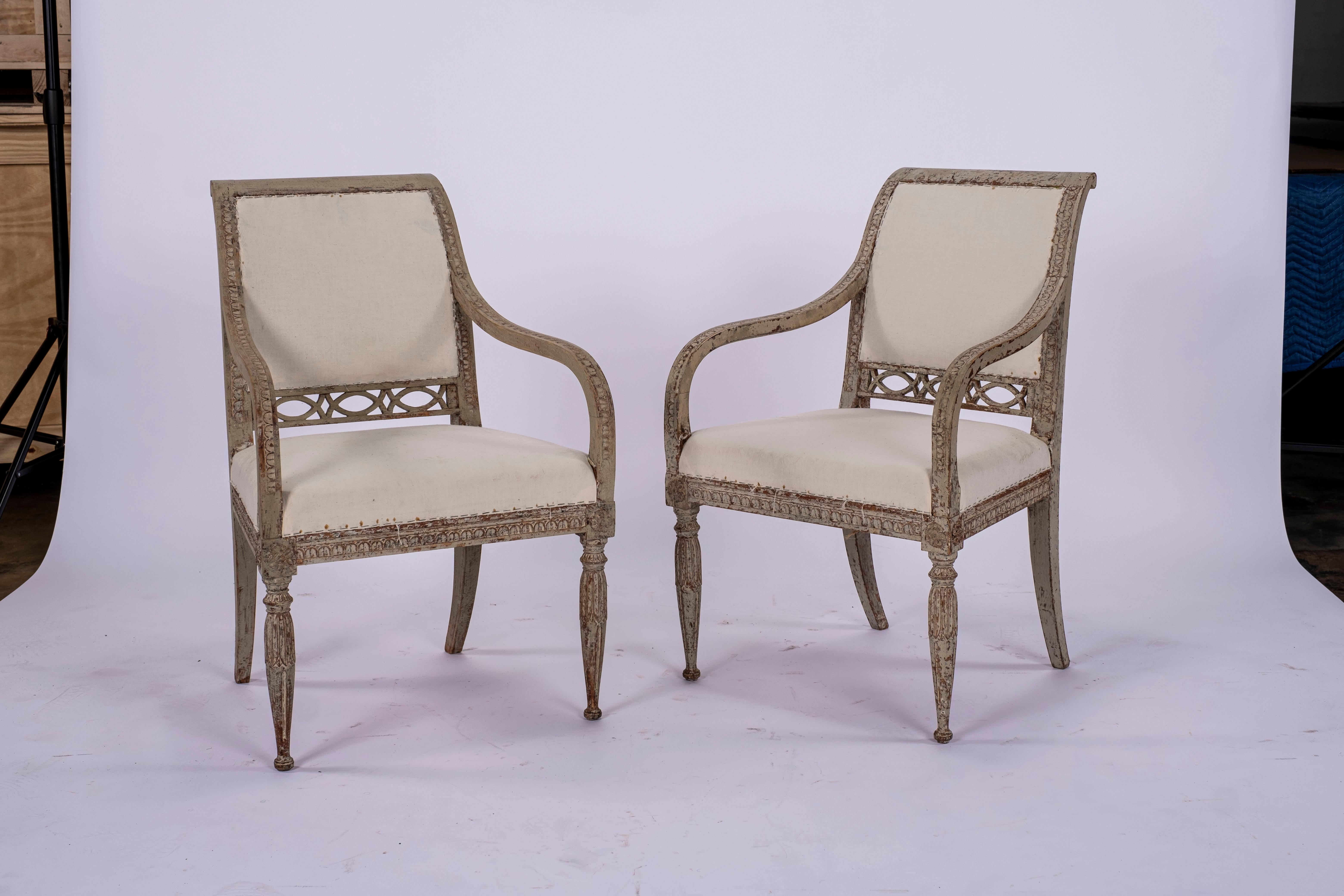 Pair of Gustavian armchairs. Ready for upholstered seat and back. Beautiful fretwork on back section. Carved detail throughout the frame with fluted tapering legs in the front and sloping klismos legs in the back..

Measures: Seat depth: 17