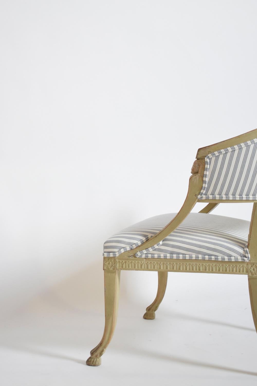 Paire de fauteuils gustaviens d'inspiration étrusque antique, reposant sur des pieds galbés se terminant par des sabots, accoudoirs décorés de visages. Suède, C.I.C.