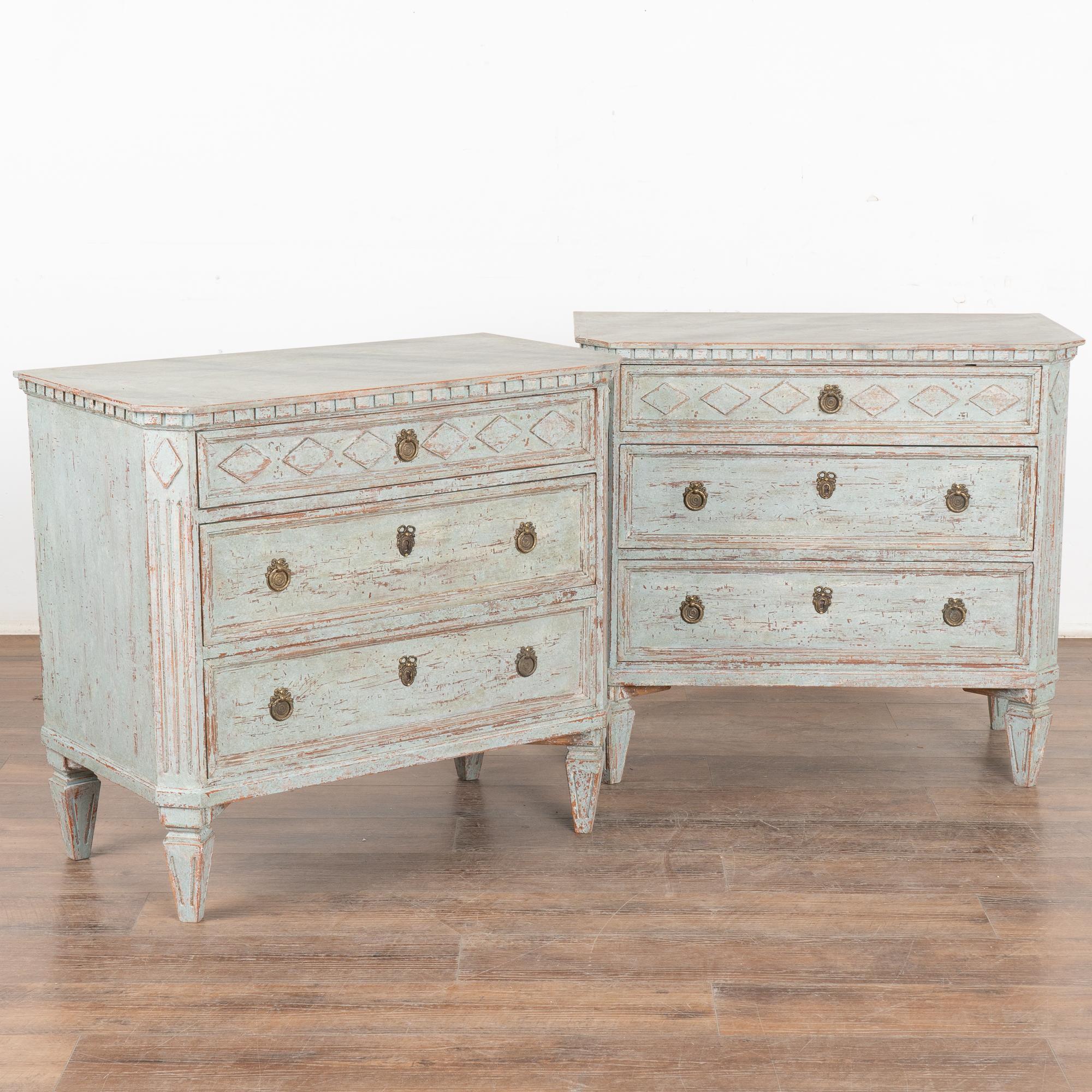 A pair of decorative Gustavian style pine chest of drawers painted in shades of blue, fitting their Swedish origin.
Canted fluted side posts with upper carved diamond medallion and top drawer with diamond pattern repeated. Raised on four tapered