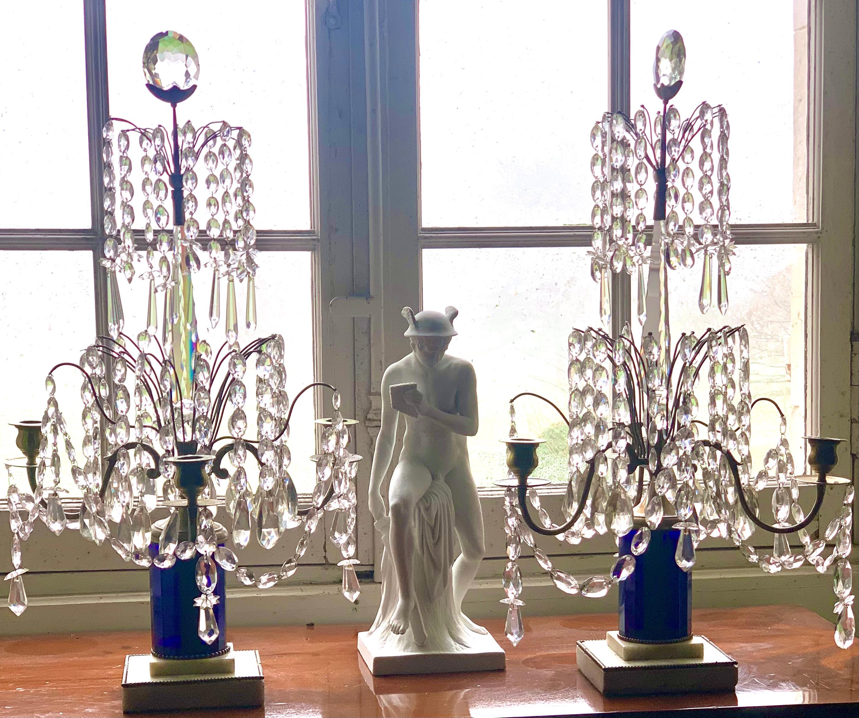 Pair of Swedish Gustavian style girandoles with three lights. 
The large crystal dagger cut with scratches bears at its top an arrow surmounted by a very luminous lens. It rests on a blue crystal barrel cut with 16 facets, which rests on a marble