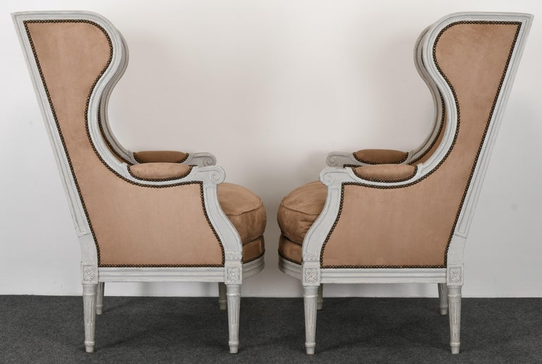 A stately large-scale pair of Gustavian Louis XVI Style Wingback Chairs, 1980s. These chairs are made in Europe, possibly Italy or France. They are handmade and pegged at the joints. There is some wearing to paint on edges, which may have been done
