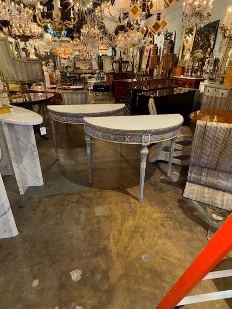 Pair of Gustavian Neo-Classical carved and painted demi-lune console tables. Circa 1940. A fine addition to any home! 43w x 21d x 43h