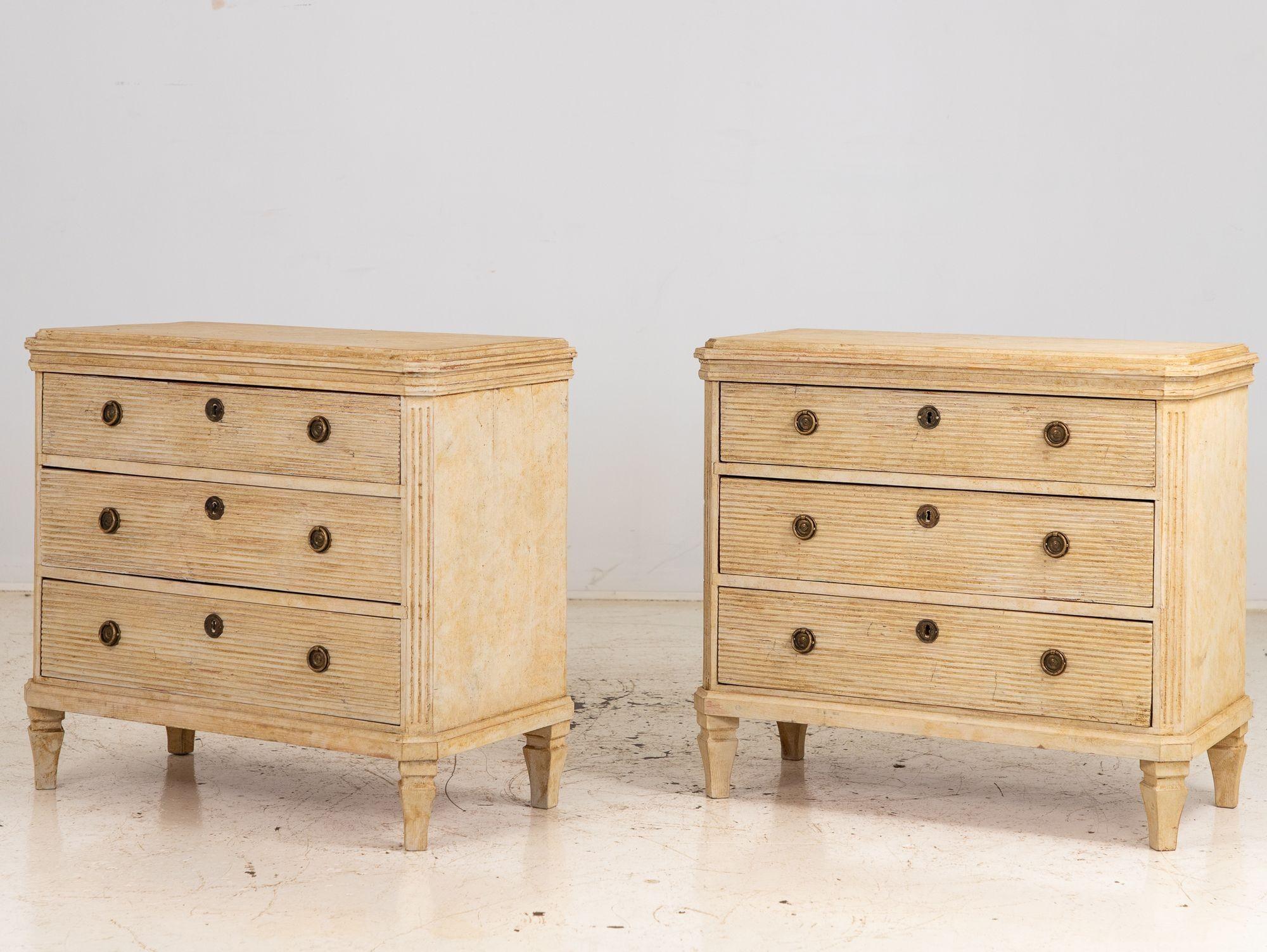 This captivating pair of Swedish Gustavian style commodes is early 20th Century. Evoking the elegant charm of the Gustavian era, these commodes embody the quintessential characteristics of Swedish design with their refined details and timeless