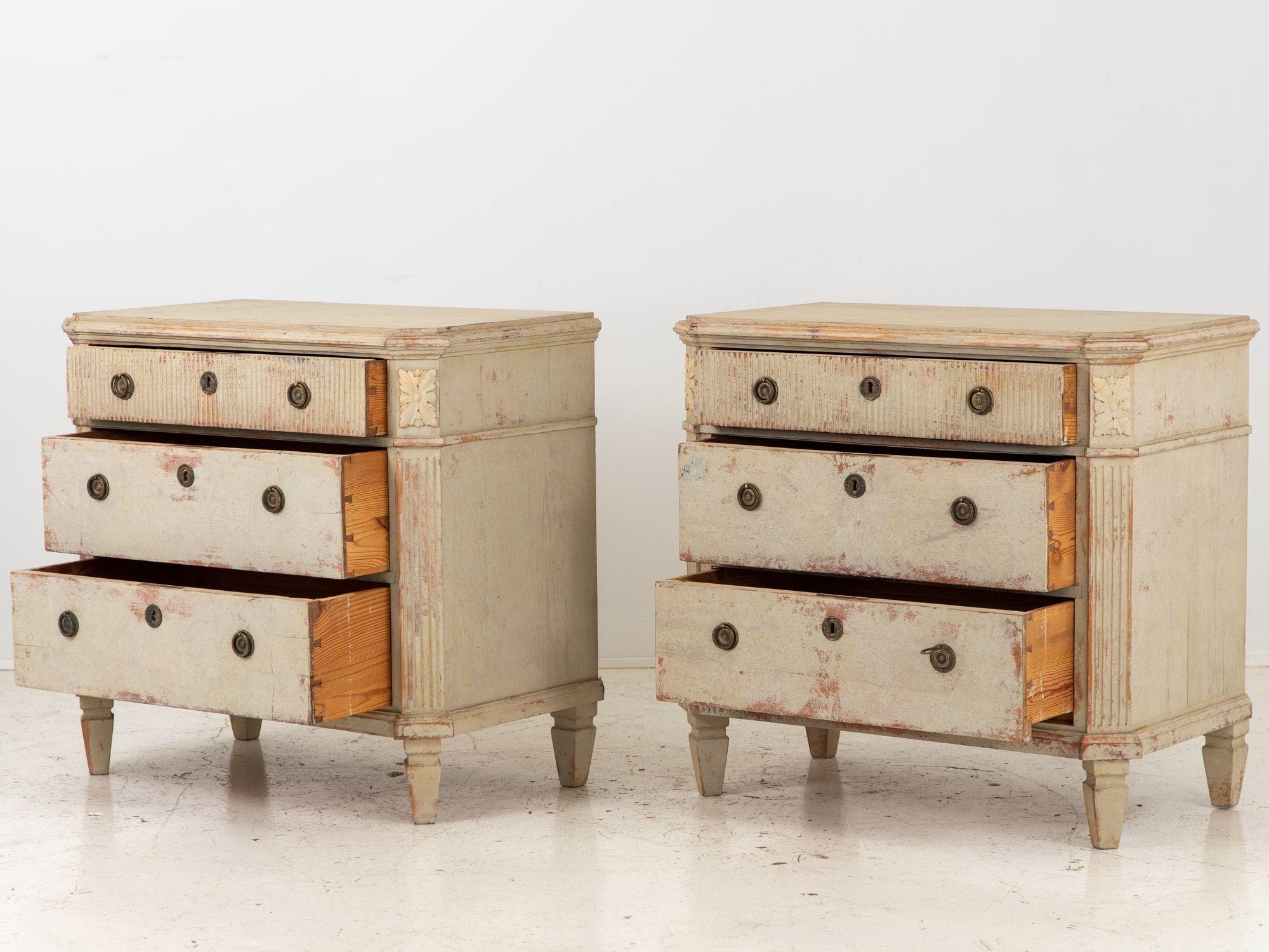 This captivating pair of Swedish Gustavian Style commodes is early 20th century. Evoking the elegant charm of the Gustavian era, these commodes embody the quintessential characteristics of Swedish design with their refined details and timeless
