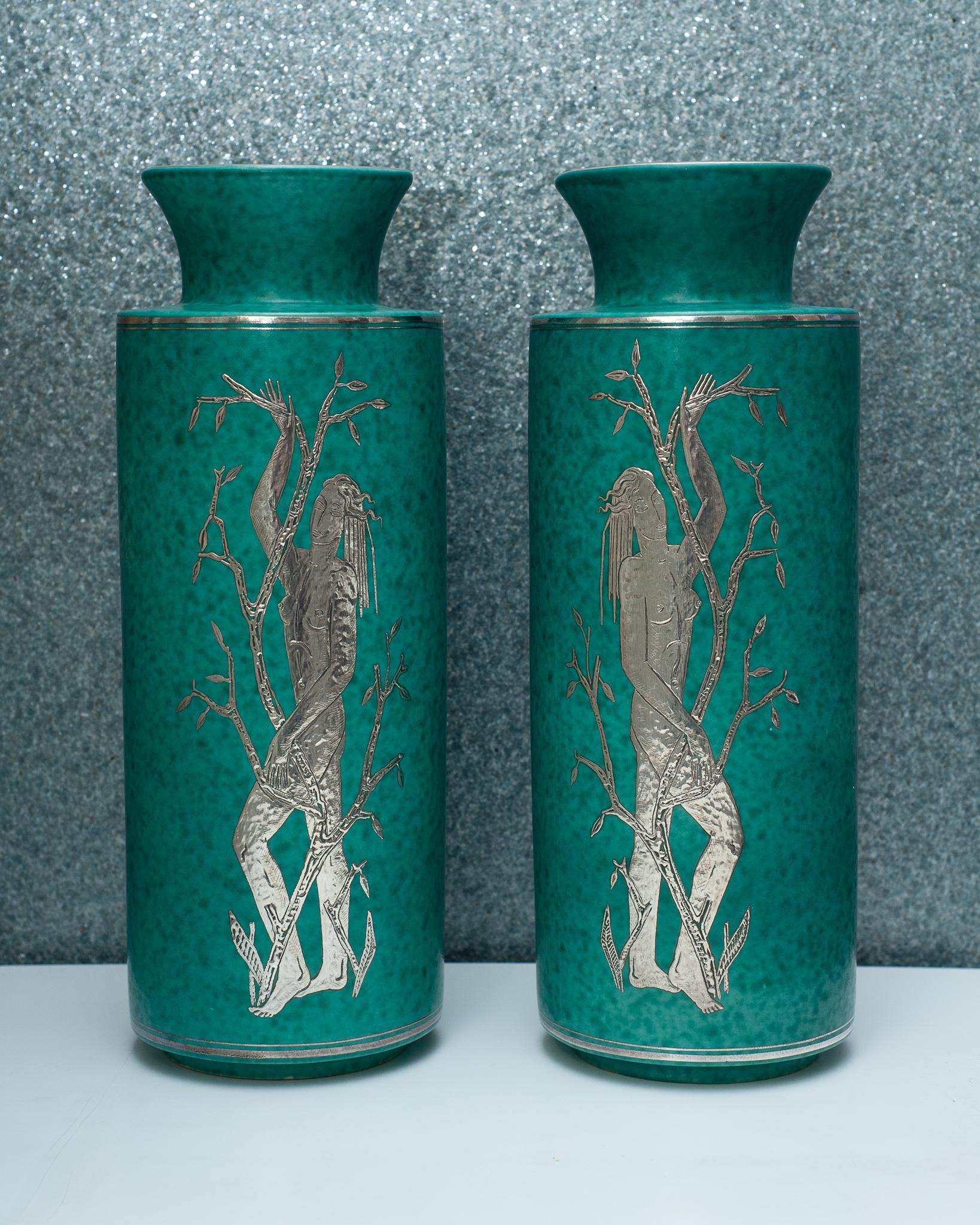 A spectacular pair of Gustavsberg Argenta vases by Wilhelm Kåge, circa 1940. The Argenta series, which encompasses vessels coated in an oxidized green glaze, and ornately decorated in sterling silver motifs, are among the most widely sought after