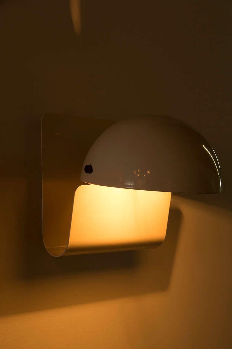 Enameled metal sconce with swivel shade that can be adjusted vertically.