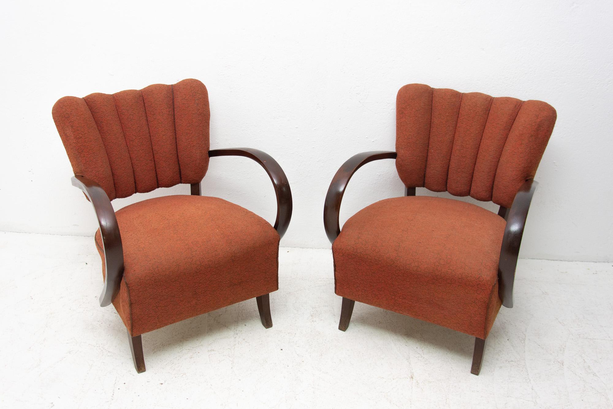 Pair of “cocktail” armchairs Catalog No. H-237 designed by Jindrich Halabala. Made in Czechoslovakia in the 1950s. Very interestingly shaped chair. It features a dark stained beech wood structure and original upholstery. The chairs are in good