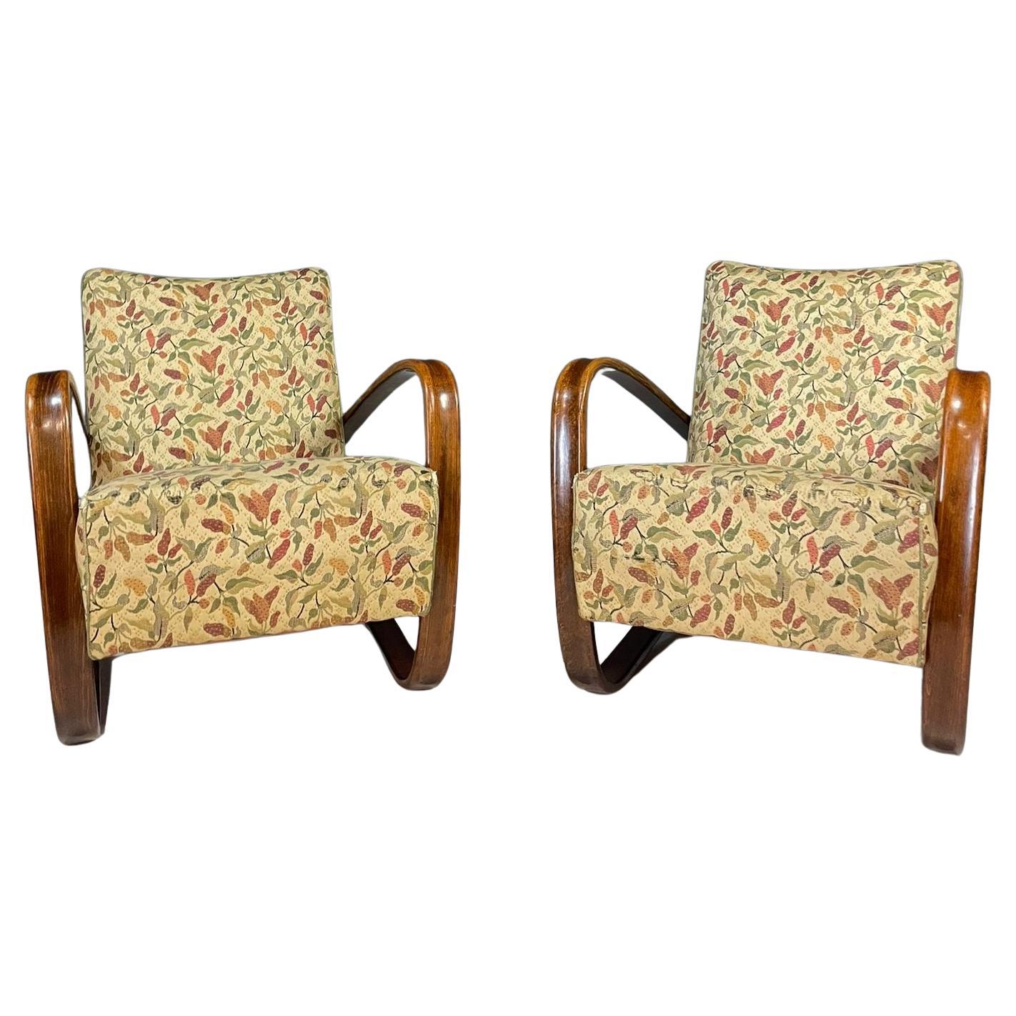 A pair of iconic H269 armchairs designed by Jindřich Halabala in the 1930s. These chairs represent the peak of Czechoslovak functionalism and Art Deco-influenced design.
They feature elegantly curved bentwood arms in dark-stained beech and their