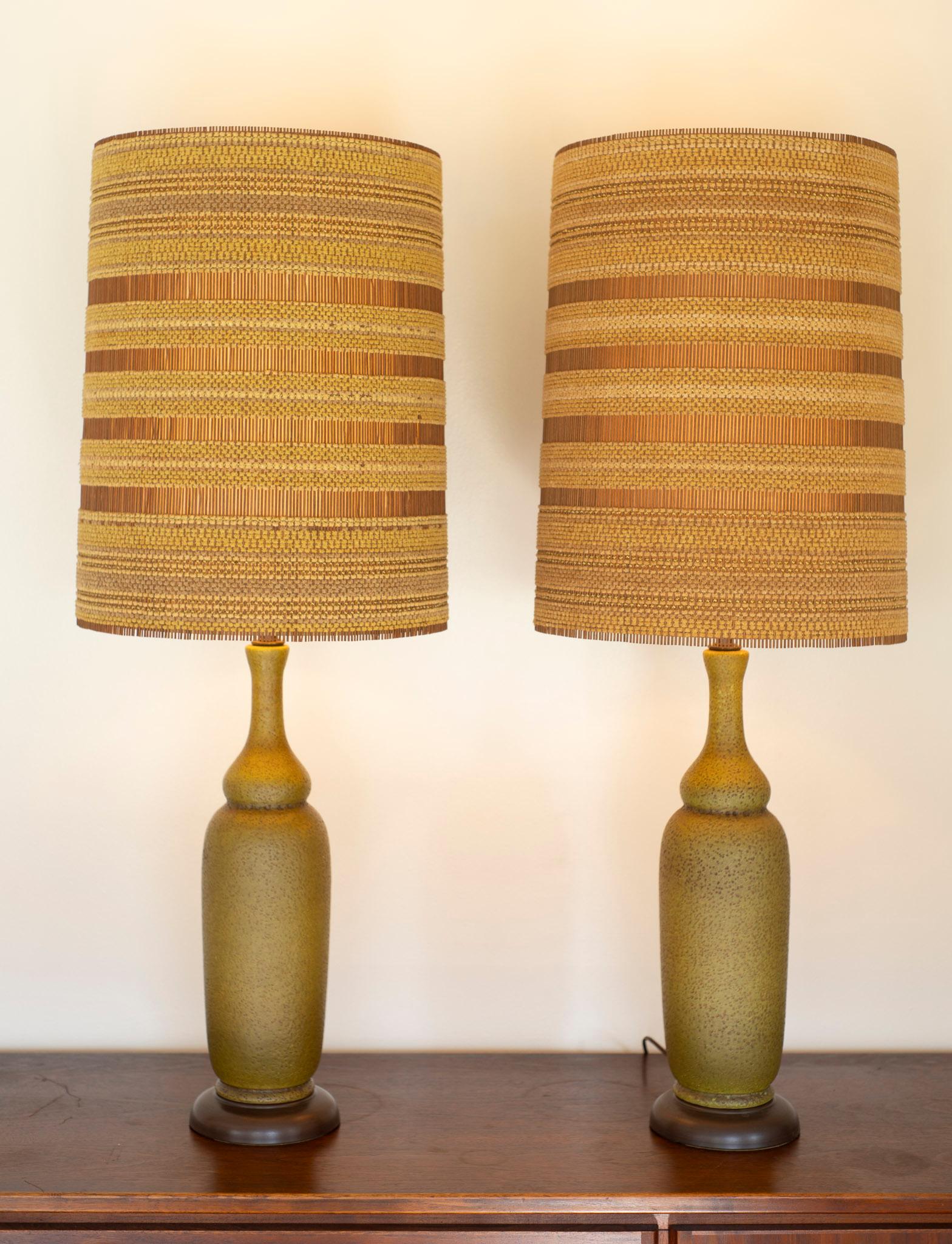 These lamps were made over half a century ago and feature a holy combination: a wonderful pair of Haeger lamp bases, made in Itlay by skilled craftsmen. These bases are made of fired ceramic, the glazed with an olive green glaze, which was agitated