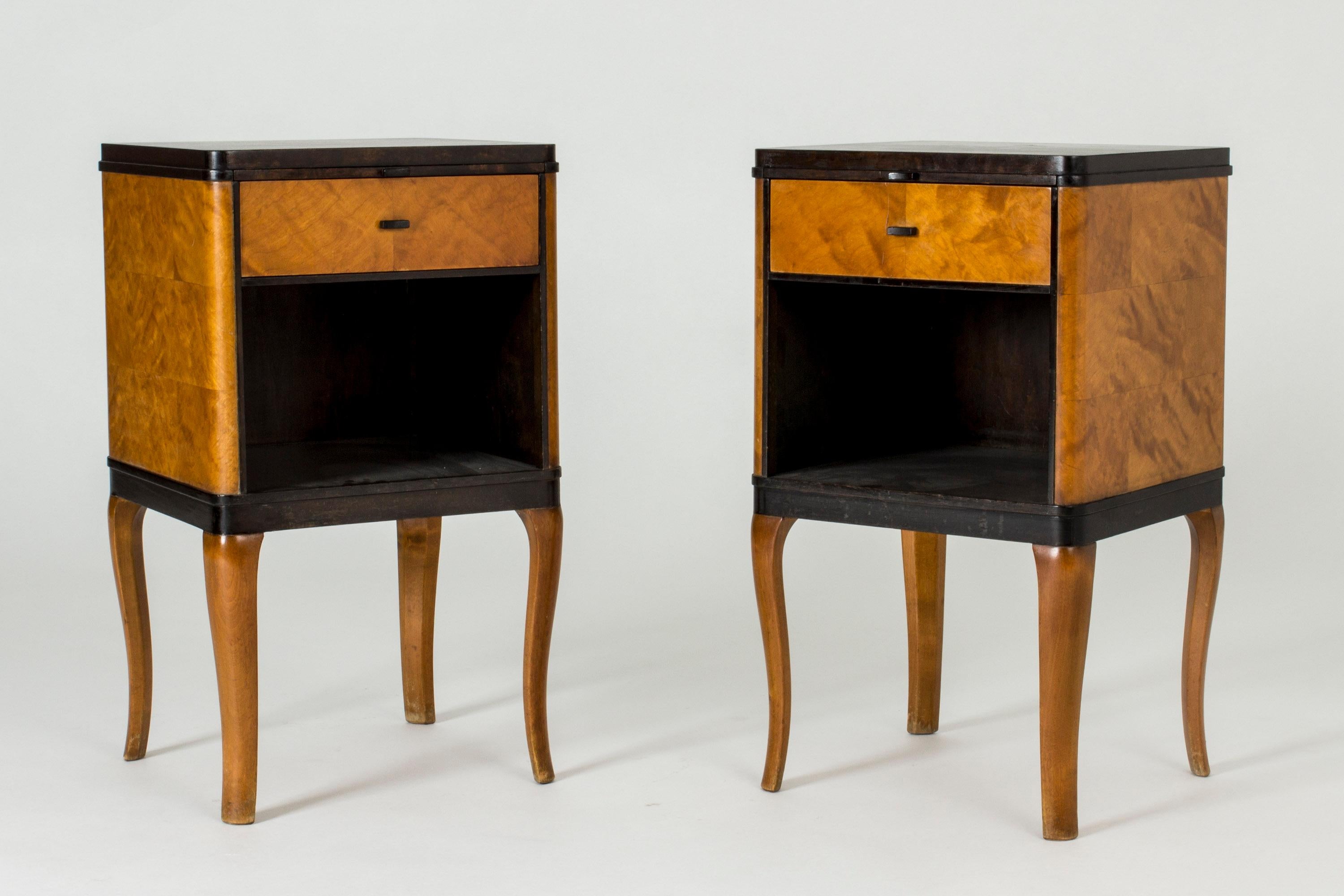 Pair of beautiful bedside tables by Carl Malmsten, model named “Haga”. Made in alder root and stained birch. On the sides the wood is laid in a checkered pattern. Curved legs connoting neo-classisim.