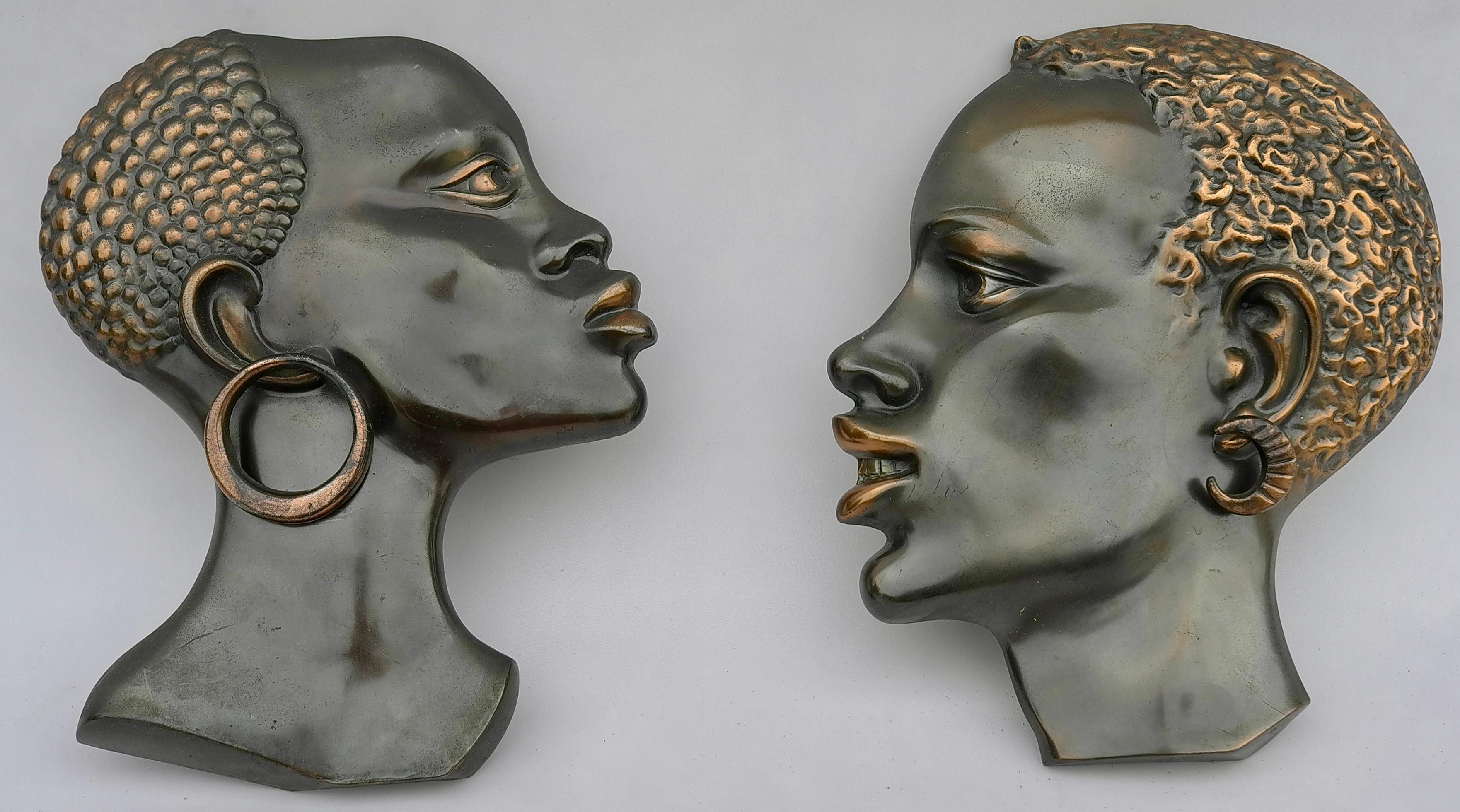 A beautiful modernist pair of brass heads of an African woman in the style of Werkstatte Hagenauer. Made in Austria in the 1950s. In very good condition with charming patina. Beautiful wall decoration pieces.
 