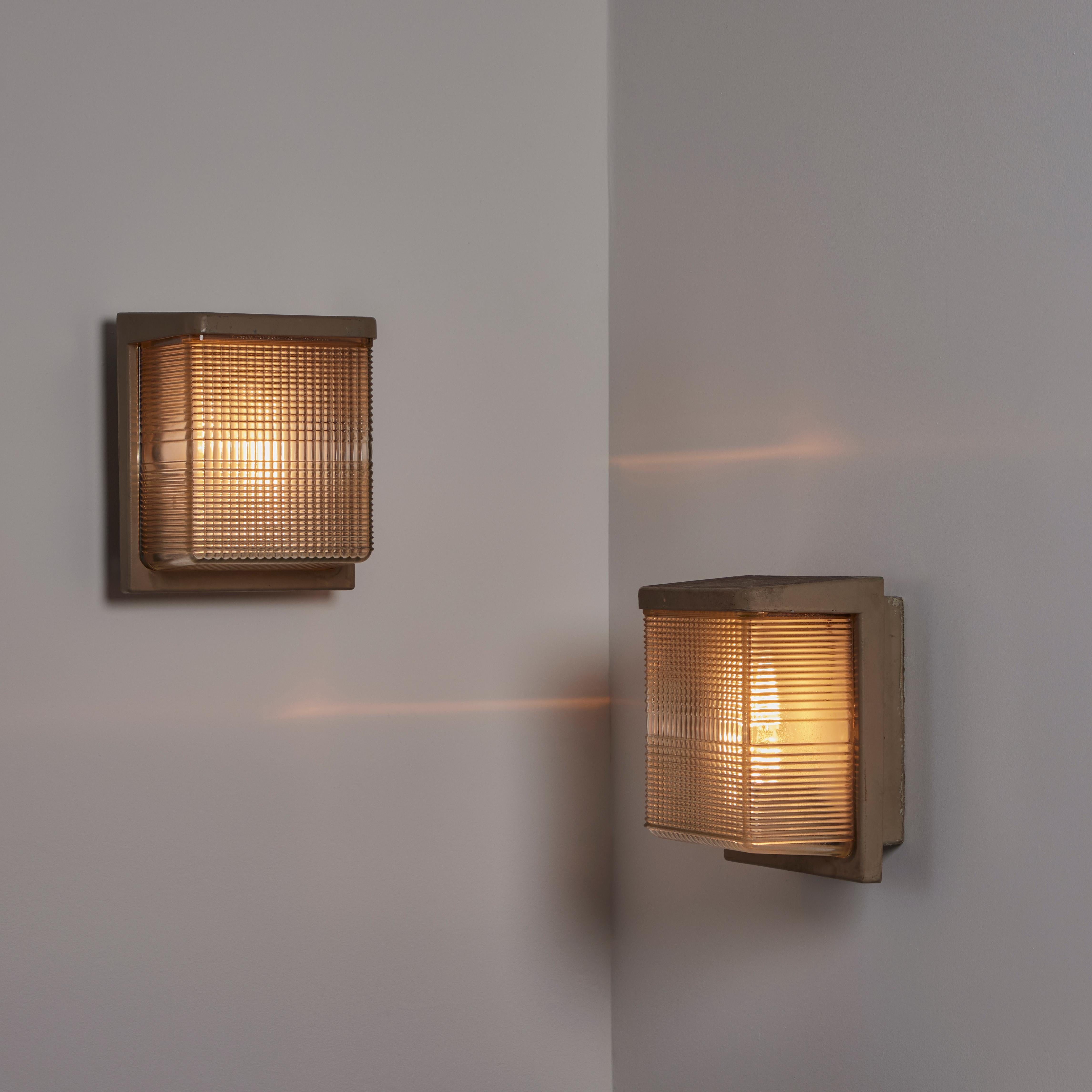 Pair of Halophane Sconces. Designed and manufactured in France, circa the 1950s. Halophane glass and enameled metal make up these classic indoor/outdoor sconces. Each unit holds a single E27 socket type, adapted for the US. We recommend a single