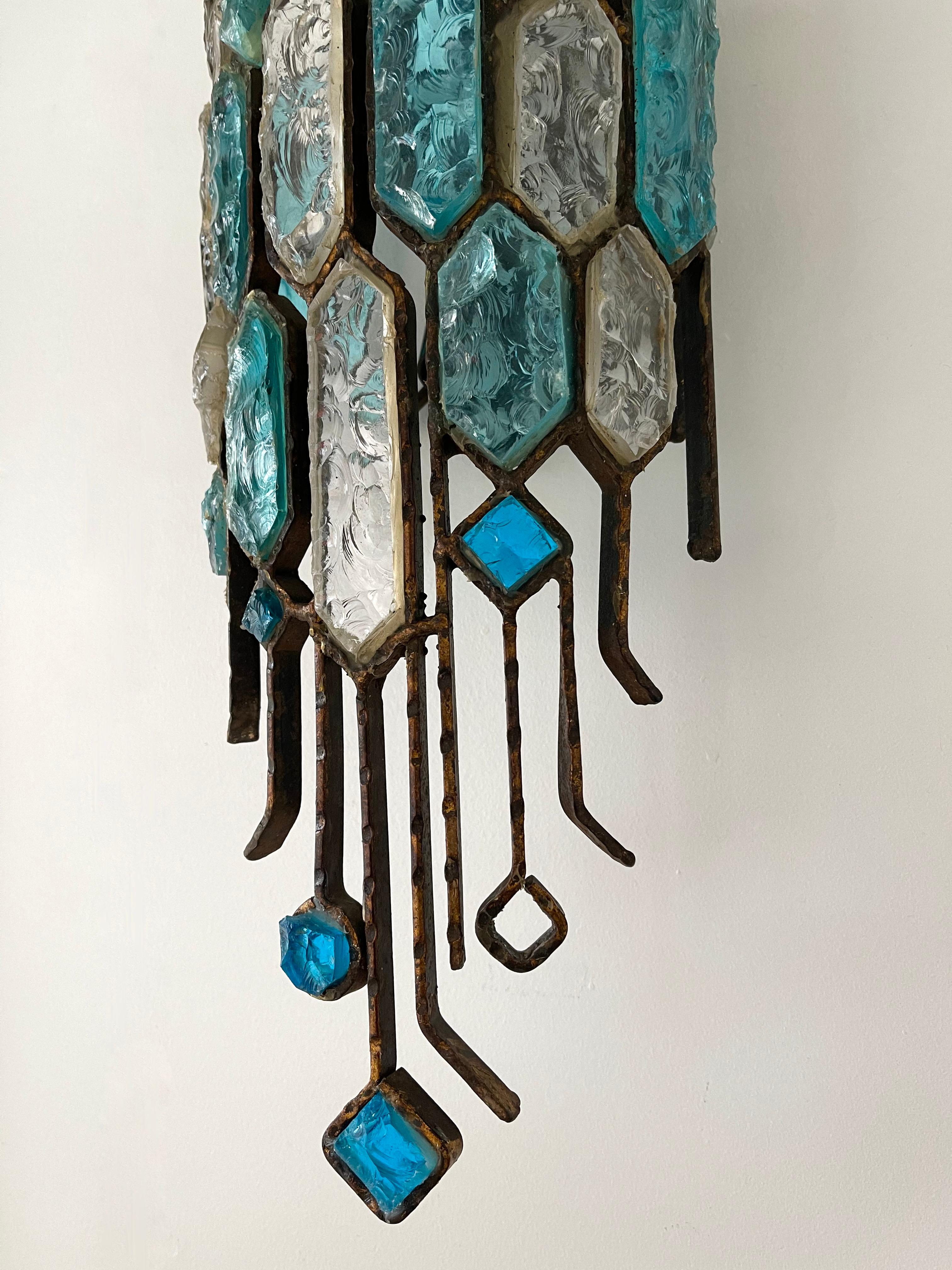 Pair of wall lamps lights sconces hammered glass and wrought iron by the manufacture Longobard in Verona in a Brutalist style, the concurrent of Biancardi Jordan Arte and Poliarte during the 1970s. Rare combination of glass blue and clear