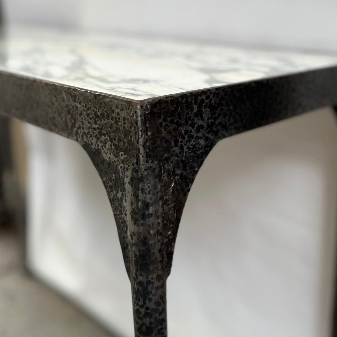 A pair of circa 1960's Italian hammered iron consoles with marble tops. Sold individually.

Measurements:
Height: 34
