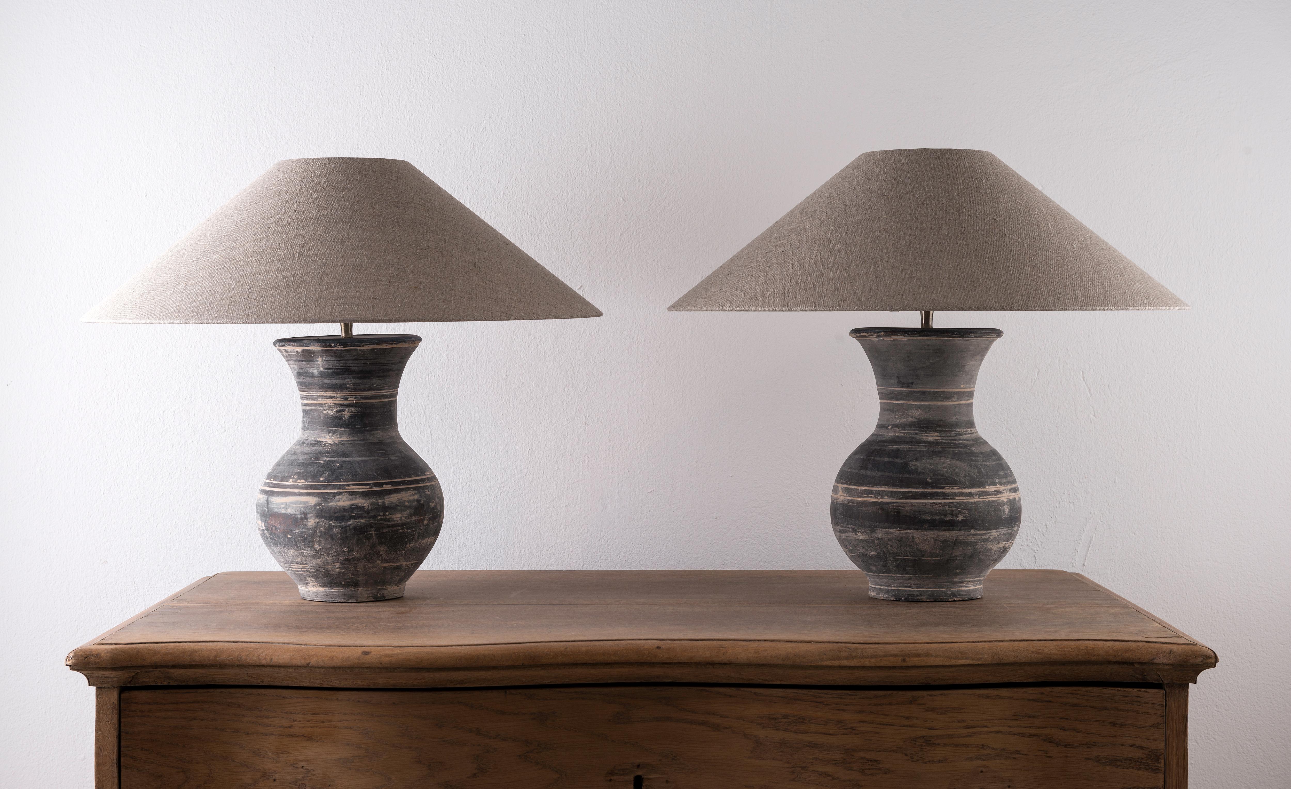 A beautiful pair of unglazed Han dynasty style vases of very elegant baluster form.
Expectedly mounted as lamps. High quality mount with a brass adjustable pivot joint. Shade handmade in Belgium.
The vases are from Zhejiang, china, mount and shade