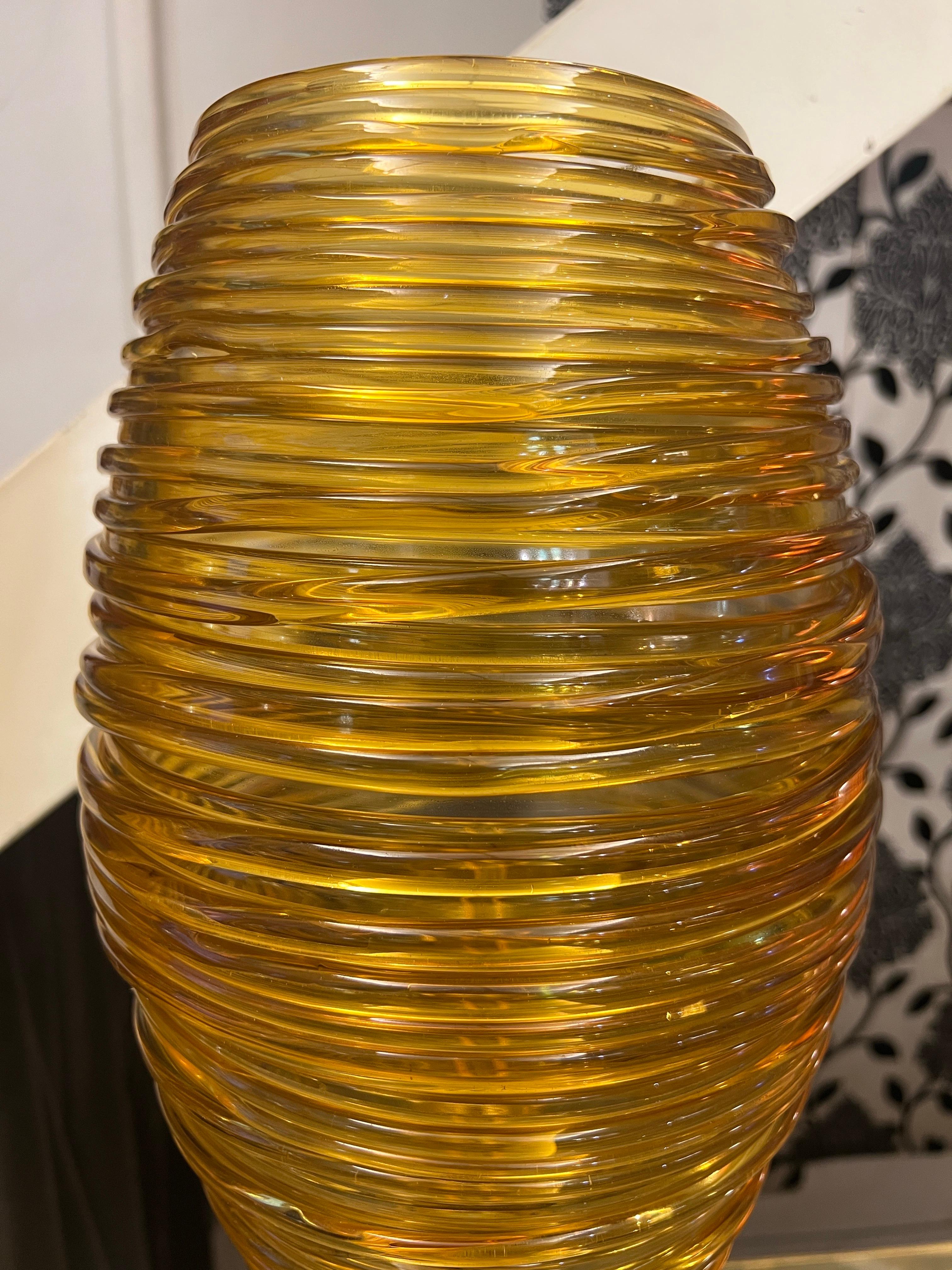 Pair of Hand-blown Amber-Colored Murano Glass Table Lamps with black Murano Glass base with brass details by Vistosi (Murano).
The cup containing a regular light bulb is made of amber- colored Murano Glass with hot hand-blown filaments applications.