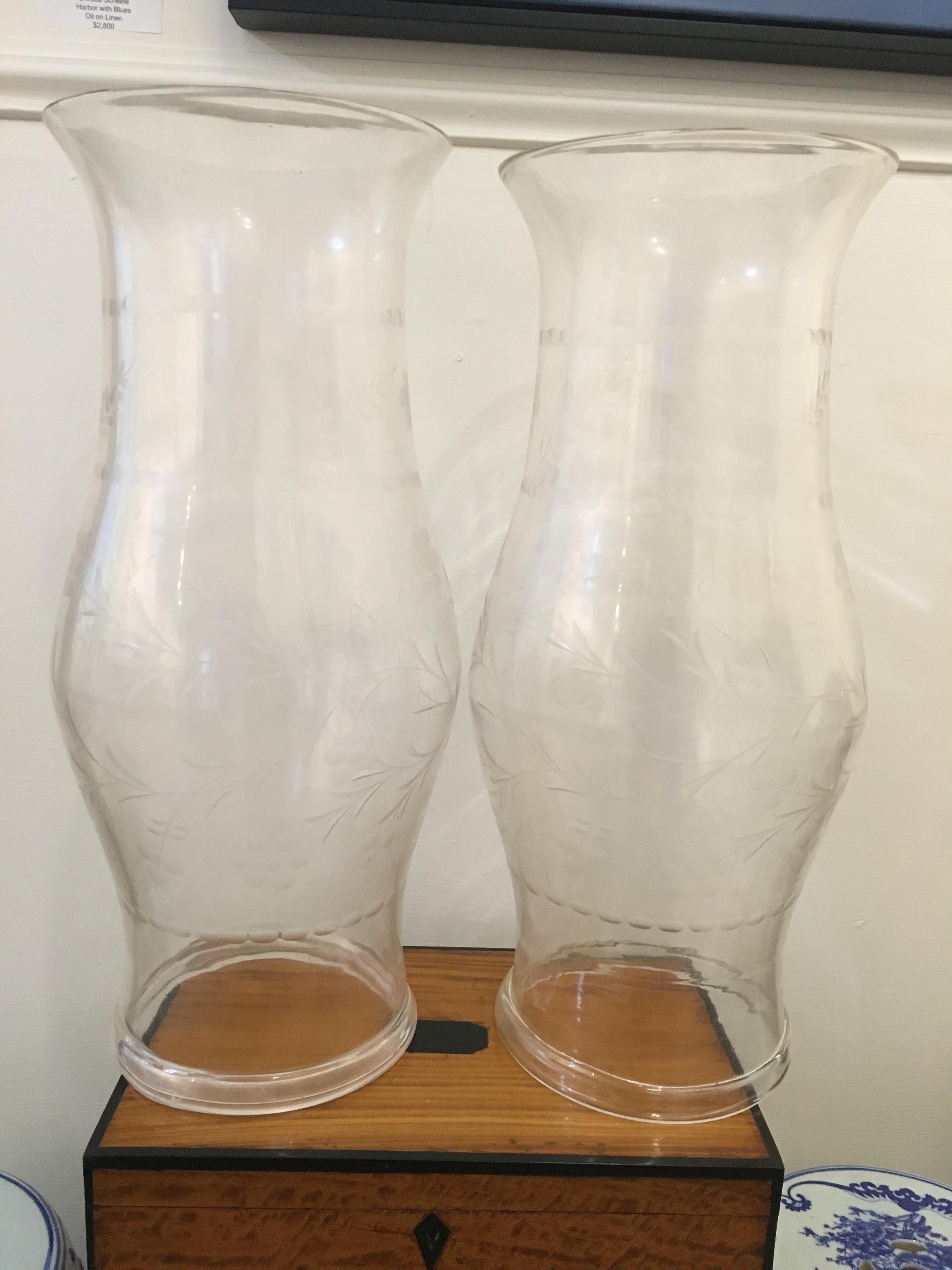 A large pair of hand blown, clear, etched hurricane shades or shield for candles, mid-1900s. English. The etching is a subtle, lovely floral vine. One small flea bite on rim, otherwise in excellent condition. Rolled bottom rim, great scale and