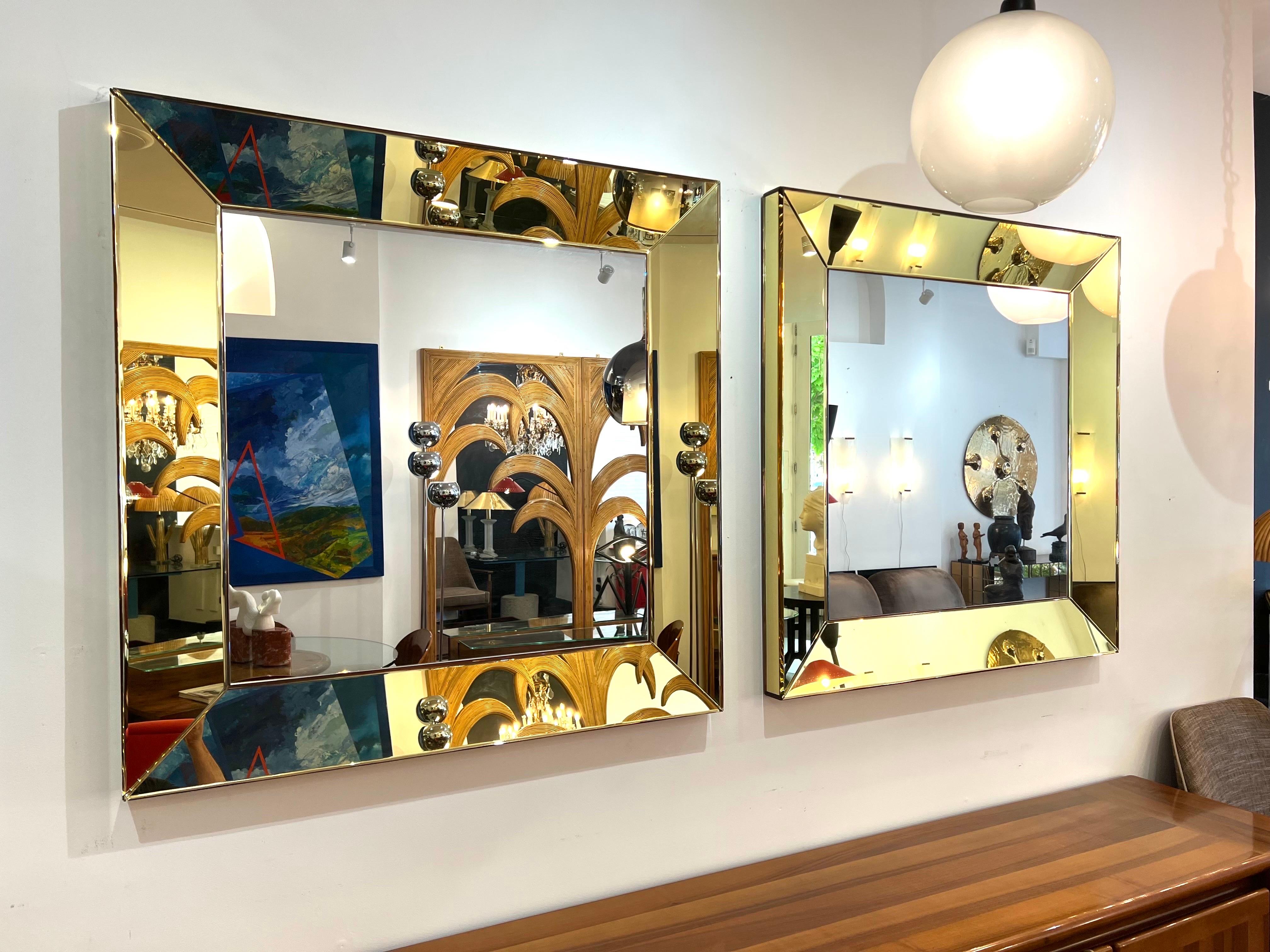 An extraordinary pair of handmade square mirrors consisting of a semi curved bevelled all mirrored frame in yellow/gold to all sides. The mirrors are 106.5cm square & 6.5cm deep (2.5in) The design and quality is equal to Roberto Rida “Gialli