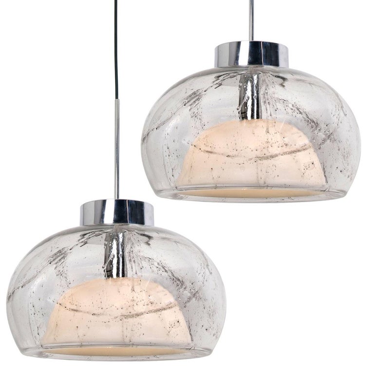 A pair of large glass chrome hanging lamps from the 1970s of the Fa. Doria. Perfectly cast from one-piece. The lamp has two different glass constructions and a chrome finish. A high quality piece. Illuminates beautiful. Beautiful! True craftsmanship