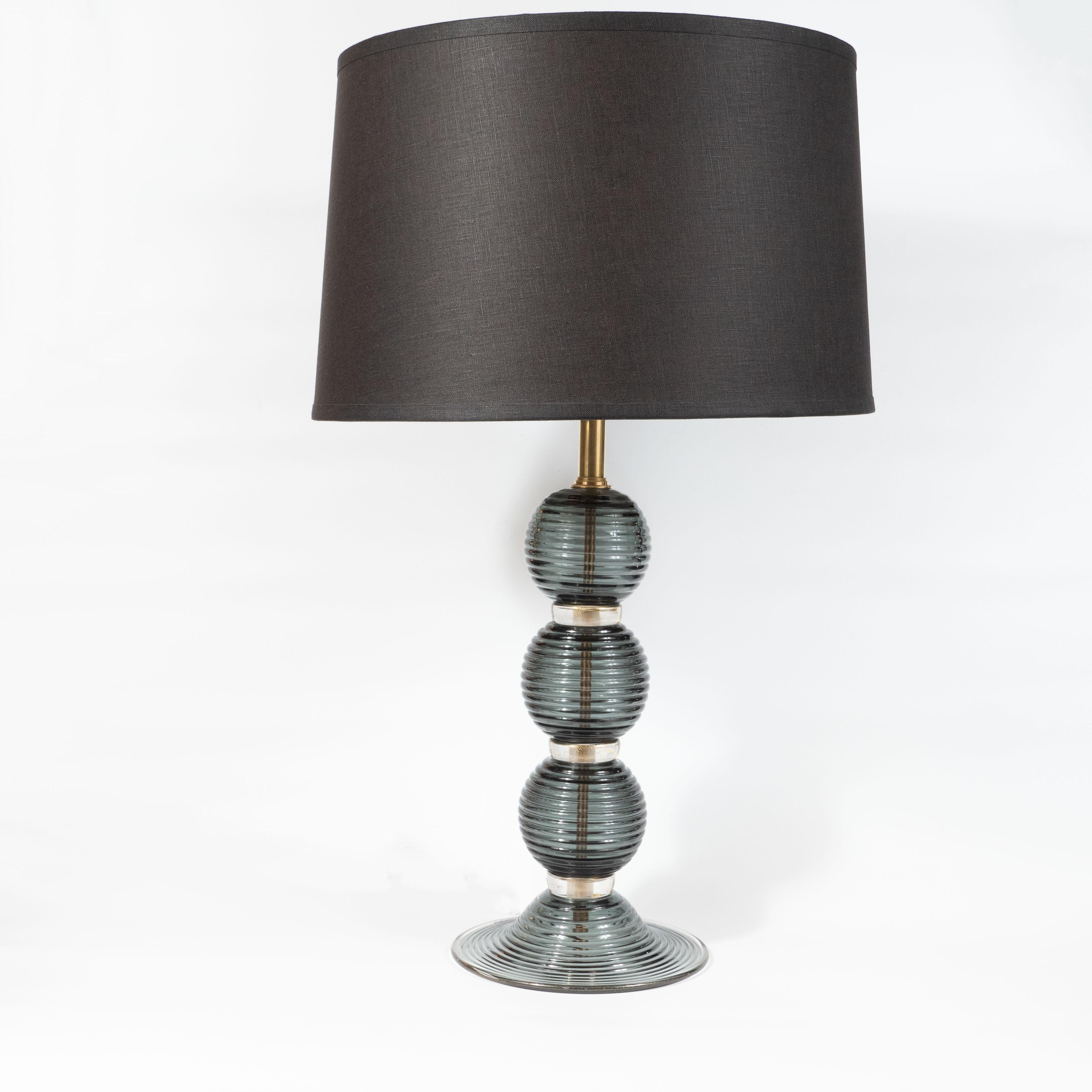 This refined pair of table lamps were realized in Murano, Italy- the islands off the coast of Venice that have been renowned for centuries for their superlative glass production. They feature three orbital forms in semi-opaque smoked graphite glass