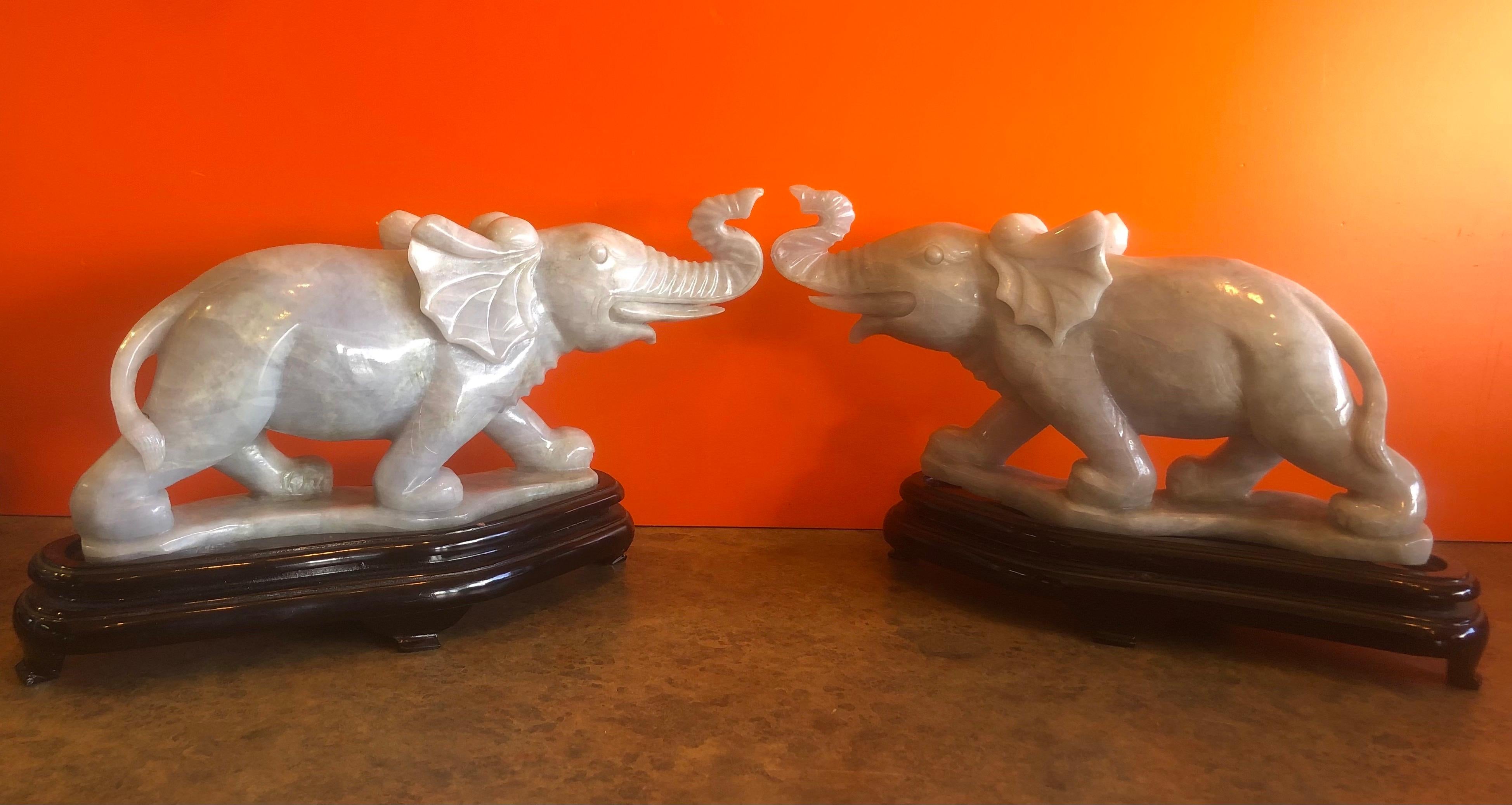 Gorgeous pair of hand carved white jade elephant sculptures on bases, circa 1960s. Impressive detail and a stunning high gloss finish with deep veining. The set is in excellent condition with no chips or cracks. Each elephant measures: 13