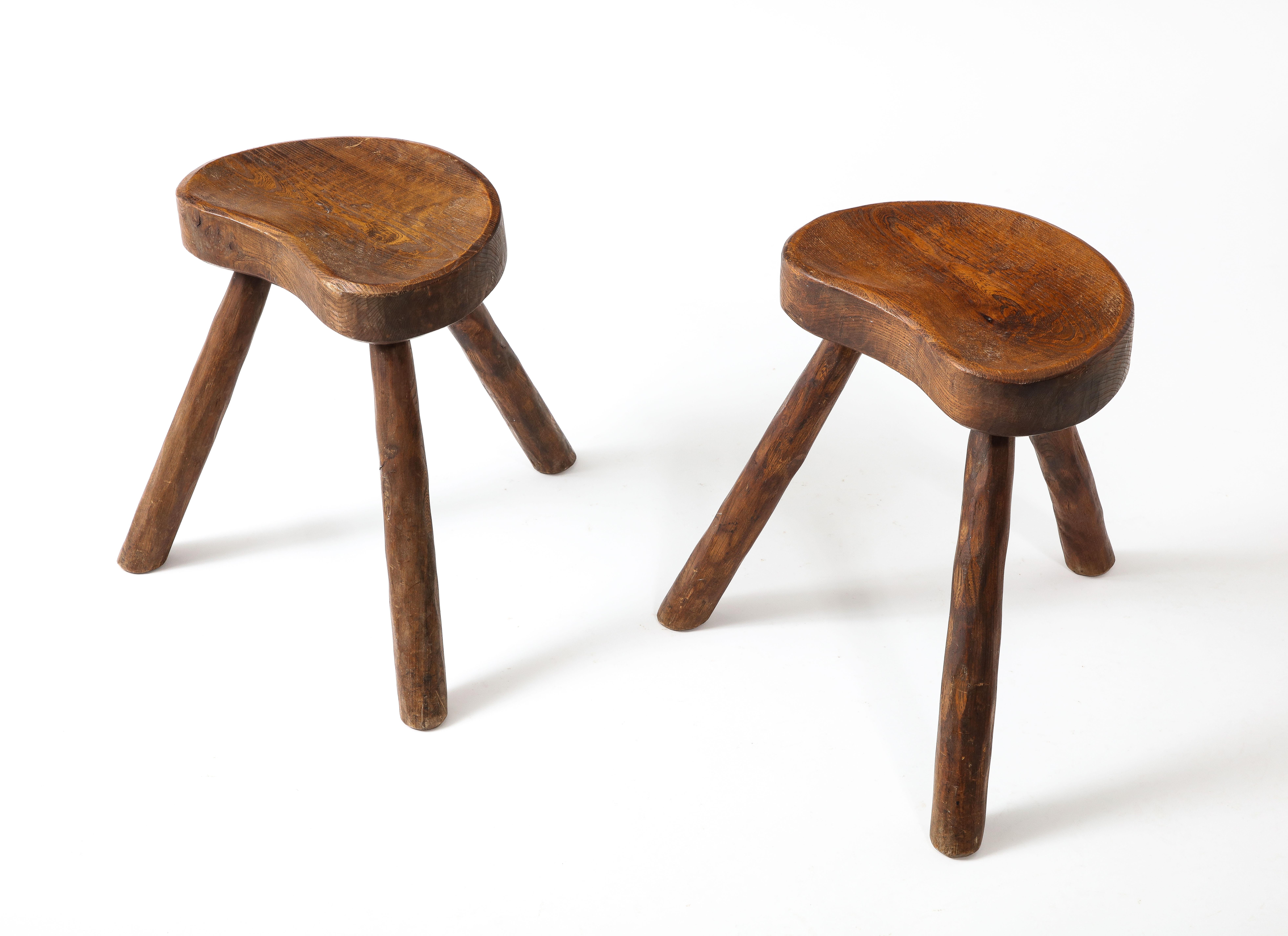 Handsome pair of stools in hand-carved stools in the Manner of Jean Touret and ateliers Marolles, Solid elm with carved and gouged seating area. Seat is 10x15. The price is for a pair. Three pairs available.