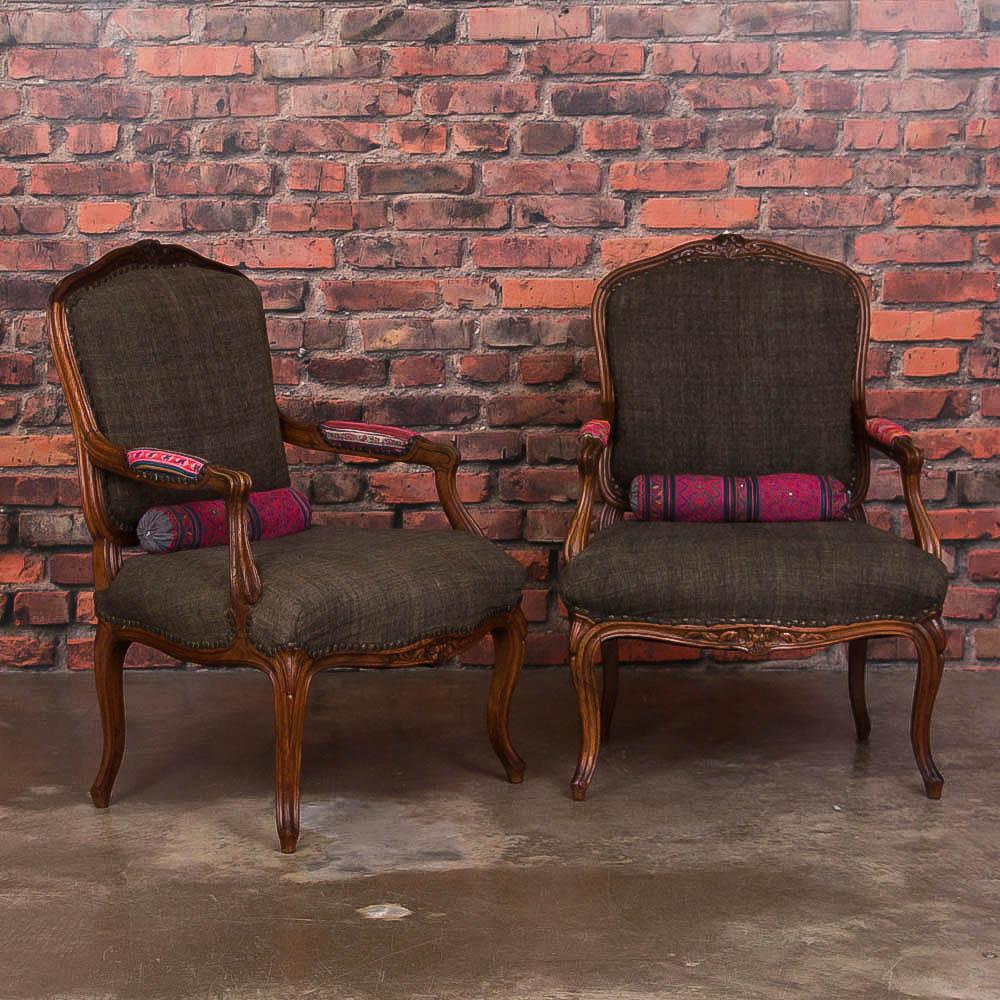 This pair of elegant late 19th century carved French walnut fauteuils has recently been upholstered with vintage Thai fabric on the arms, as well as the custom bolsters. Please enlarge the photos to appreciate the carved details and gentle curves