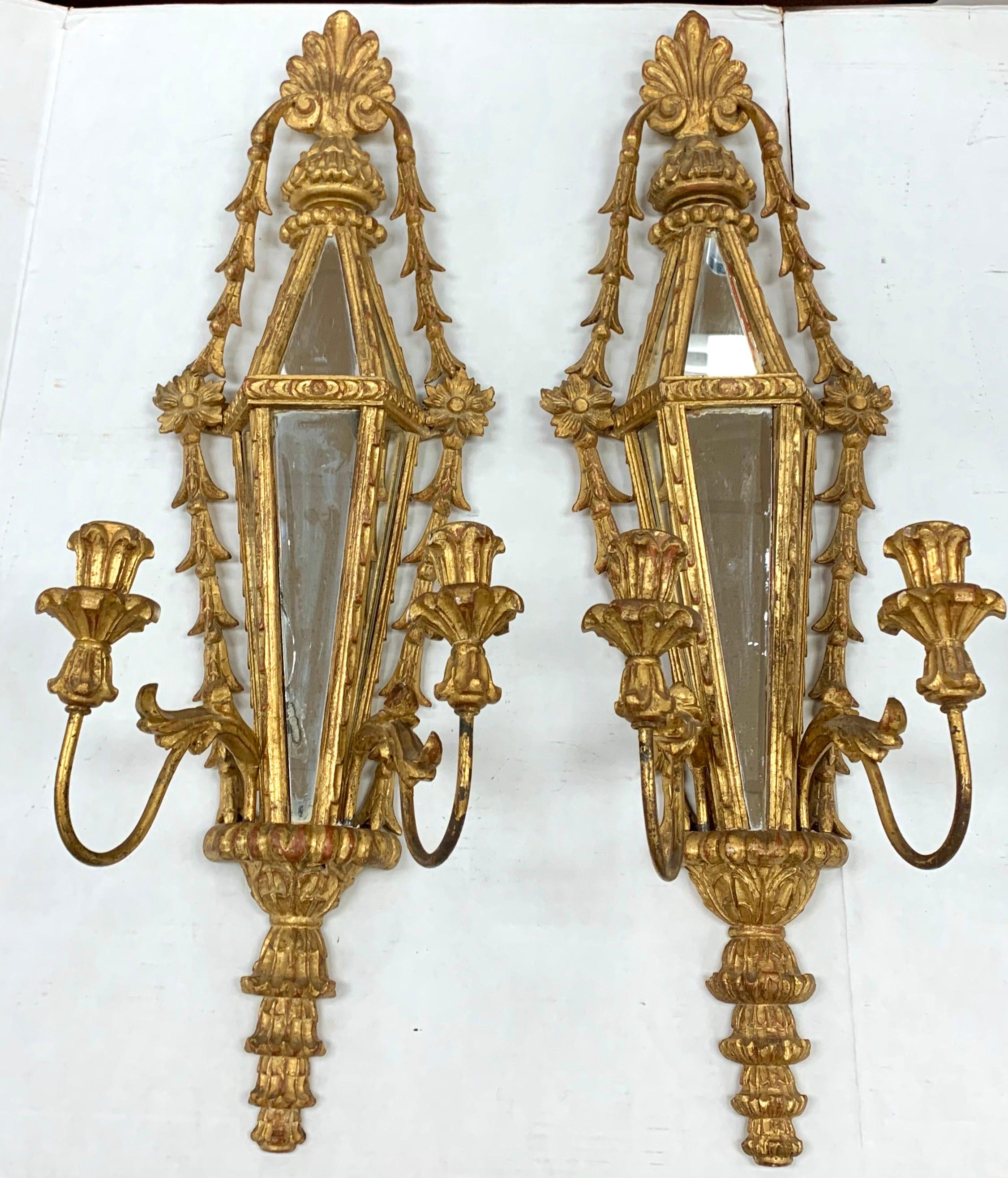 Lovely tall giltwood mirrored two arm candle sconces from Italy. Arms are detachable. Marked “Palladio Handcarved in Italy”. Beautiful details and patina.