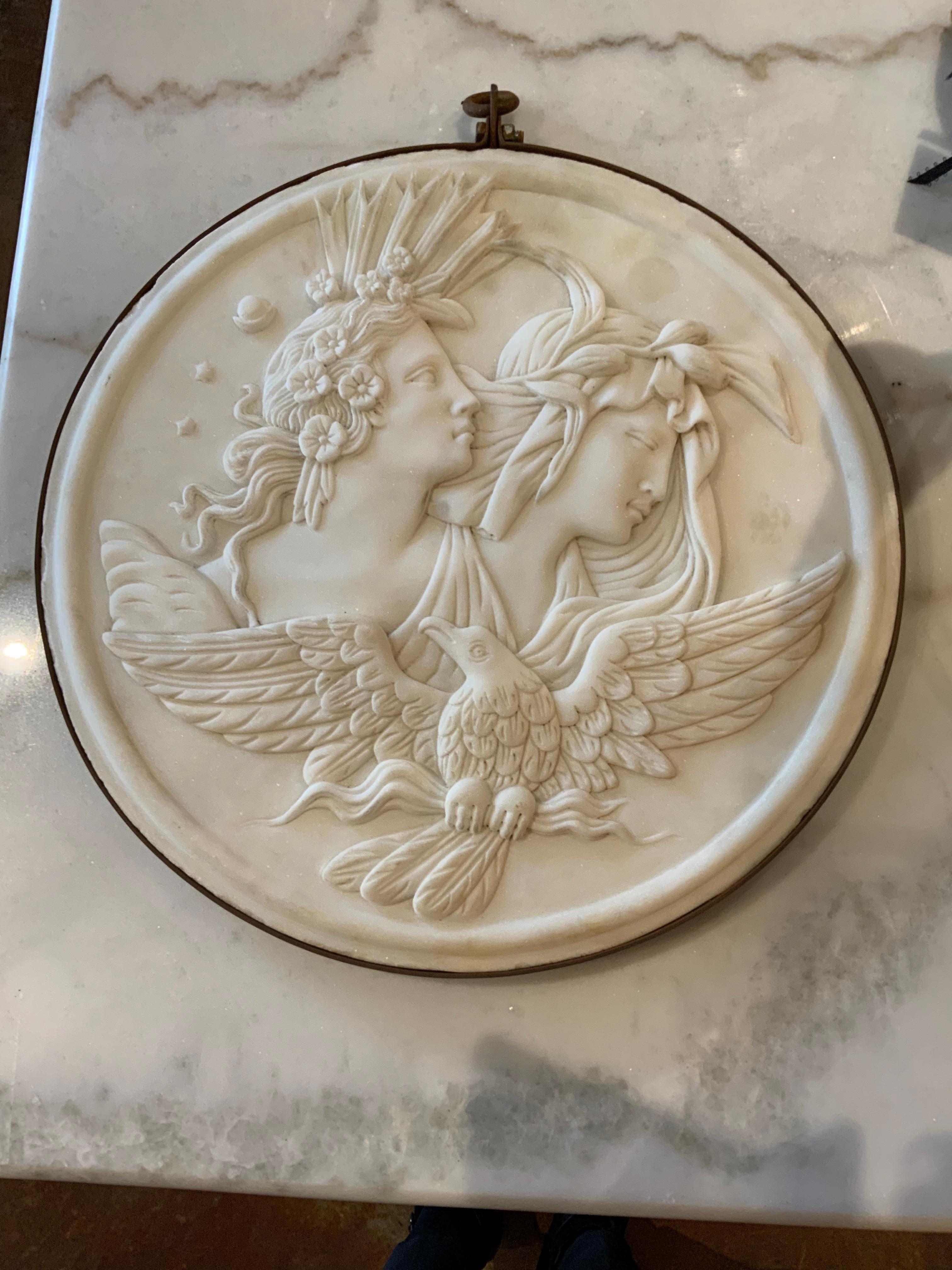 Cette paire spéciale de plaques en marbre italien de Carrare est fabriquée à la main
Sculpté avec les têtes d'un homme et d'une femme avec une colombe
Des embellissements floraux et feuillus décorent ces objets artistiques
Plaques. Ils sont