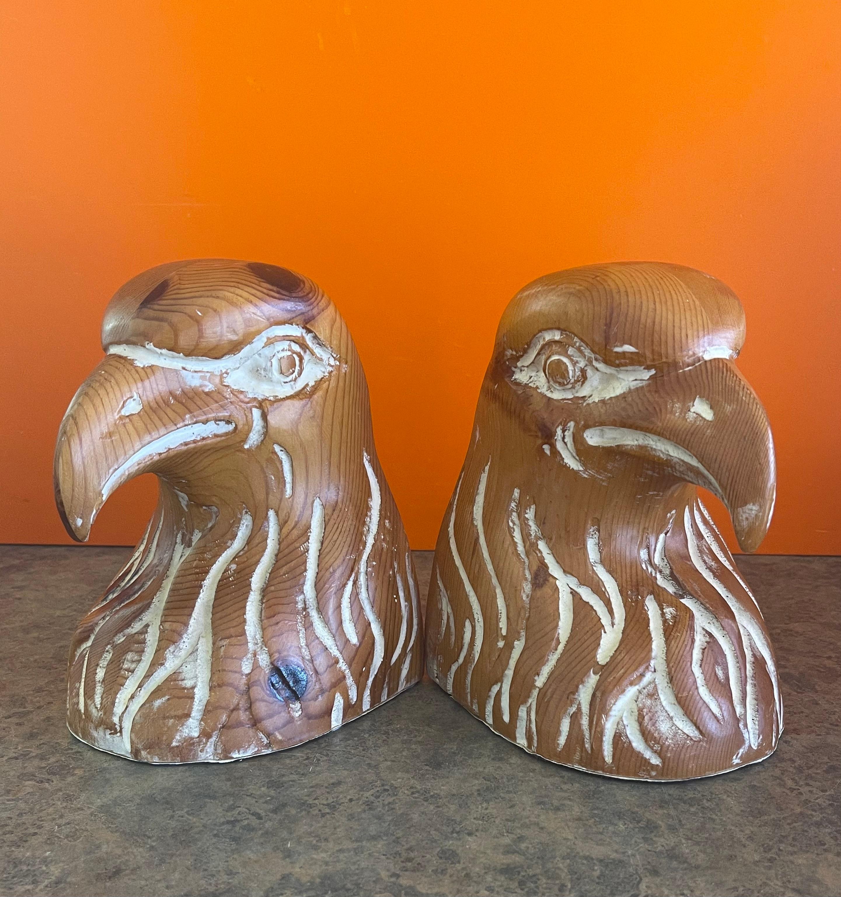 A striking pair of hand carved knotty pine eagle head bookends by Sarreid, circa 1970s. The bookends, which were made in Spain, are in very good condition and have a white wash overlay finish. They measure 10