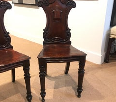Pair of Hand Carved Mahogany Armorial Hall Chairs