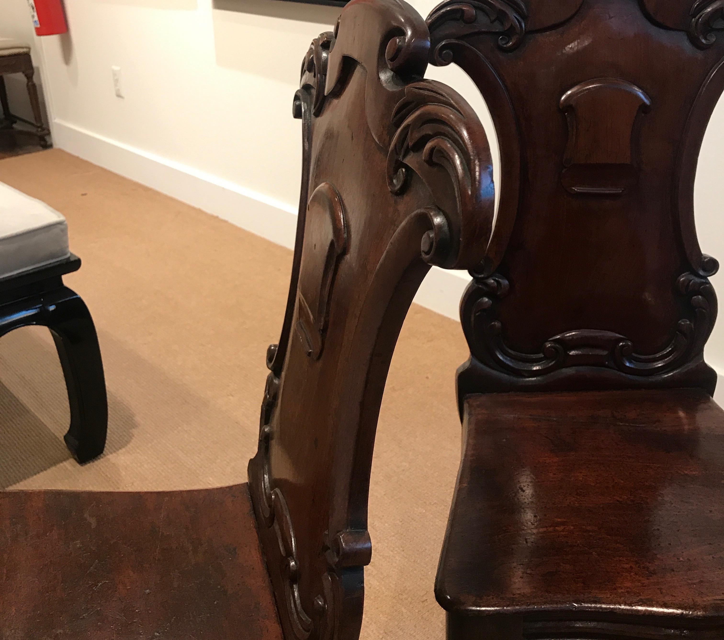 Pair of Hand Carved Mahogany Armorial Hall Chairs In Good Condition For Sale In Lambertville, NJ