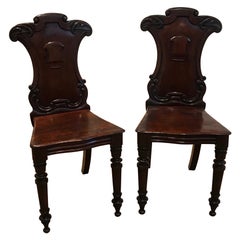 Pair of Hand Carved Mahogany Armorial Hall Chairs