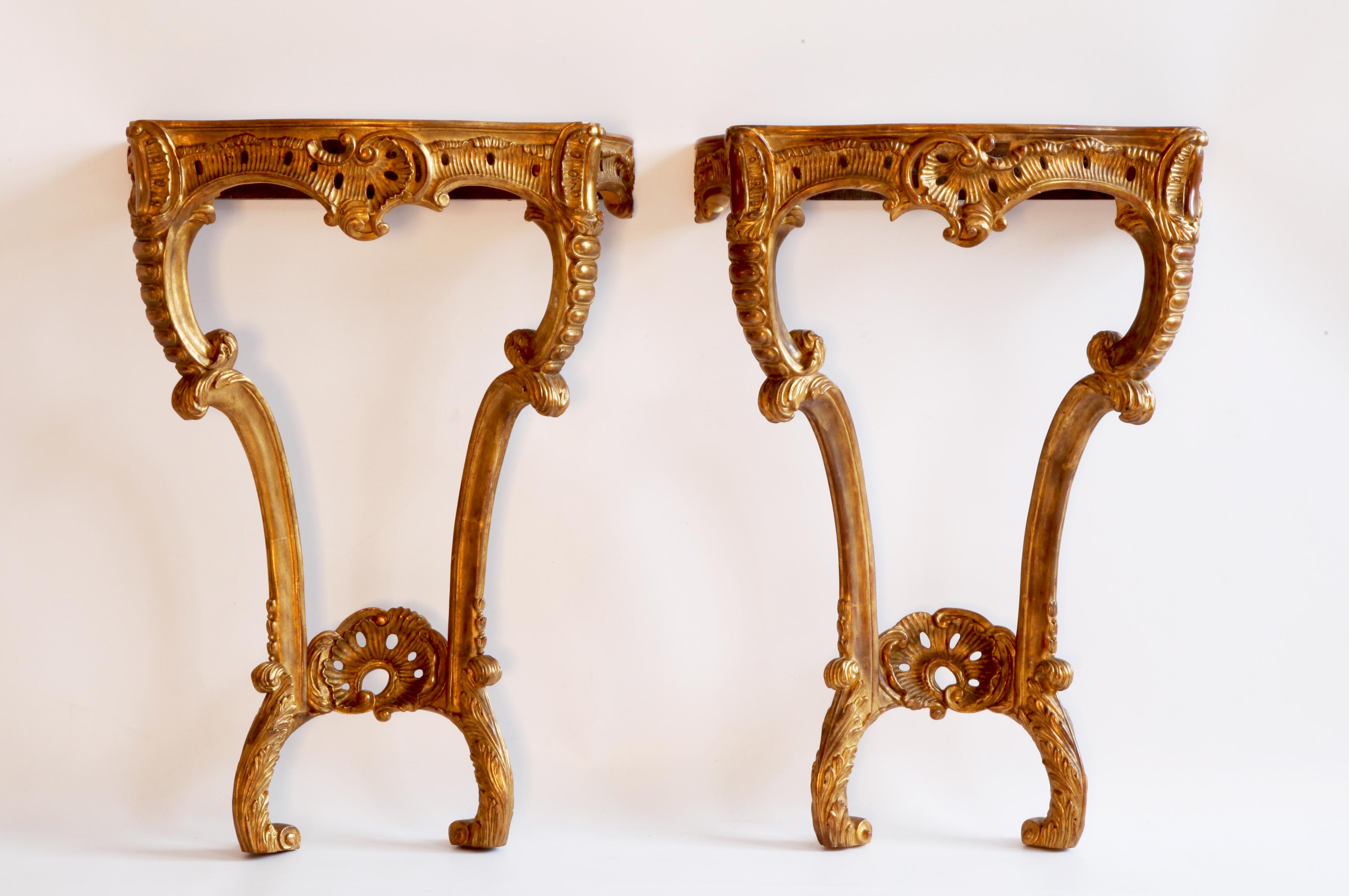 Pair of Rococo style consoles: elegantly sculpted by master craftsmen and finished with an antique gilded patina using traditional methods and materials. 

We have a selection of marble to choose from. (prices on request).