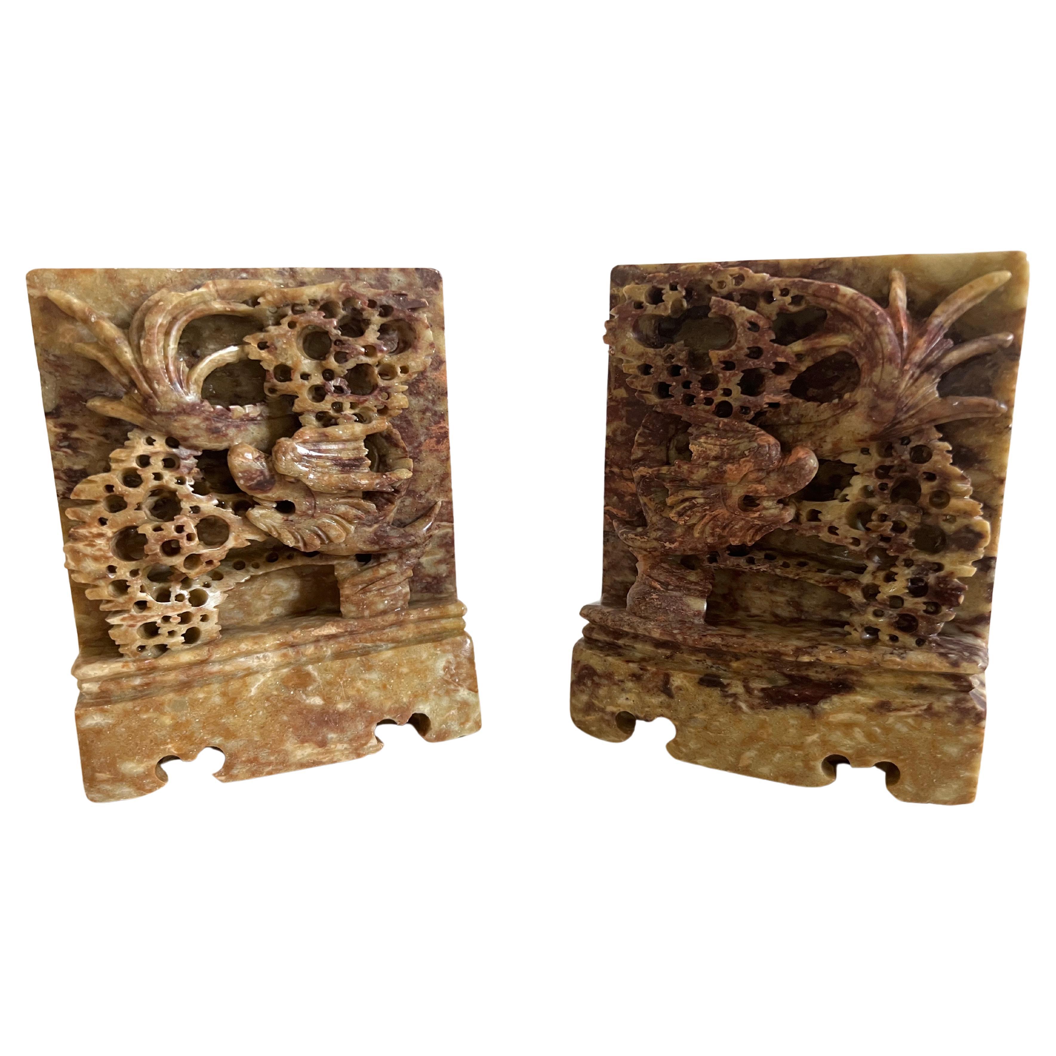 A pair of finely hand-carved soap stone bookends featuring high relief landscape scenes with dragon heads. Perfect to use on a desk as a paper weight or decorative object around the house or office. Highly decorative and fitting for any interior