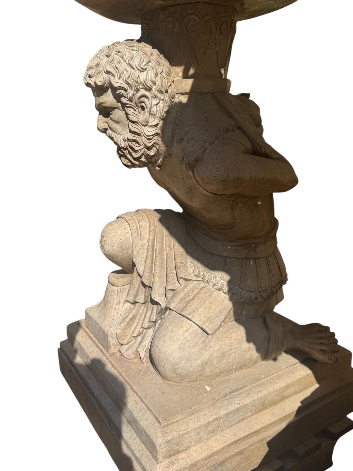 Una straordinaria coppia di grandi piedistalli scultorei, scolpiti a mano in marmo travertino italiano, ognuno dei quali rappresenta una figura umana che sostiene una piattaforma o una base. Questi intagli espressivi e audaci fondono la funzionalità