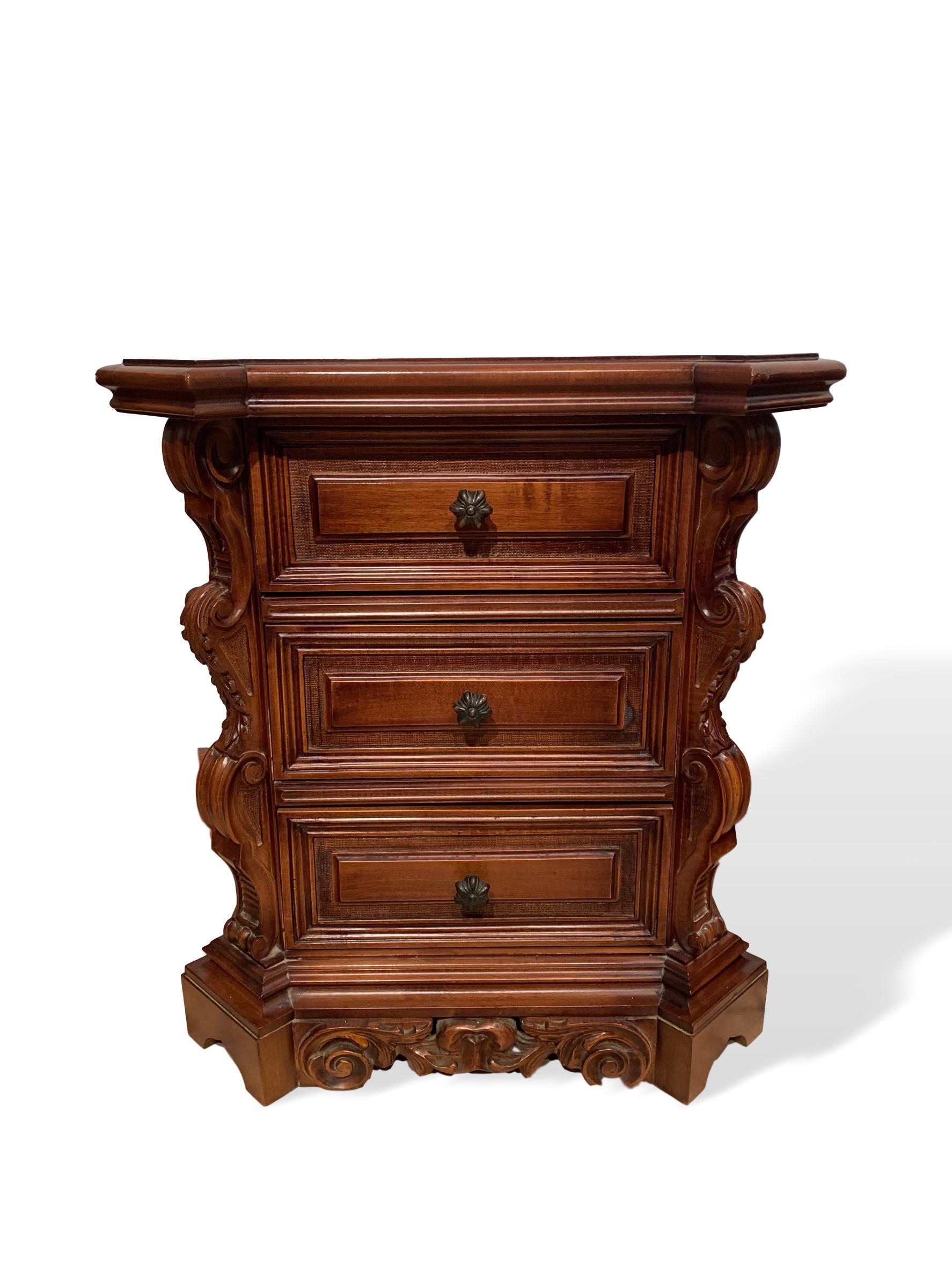 With a canted and stepped top, above three shaped and raised paneled drawers, flanked by canted corners with hand carved and graduated lonic columns, on a carved and molded bracket plinth base.

Measures: D-16 x W-26 x H-28 inches.