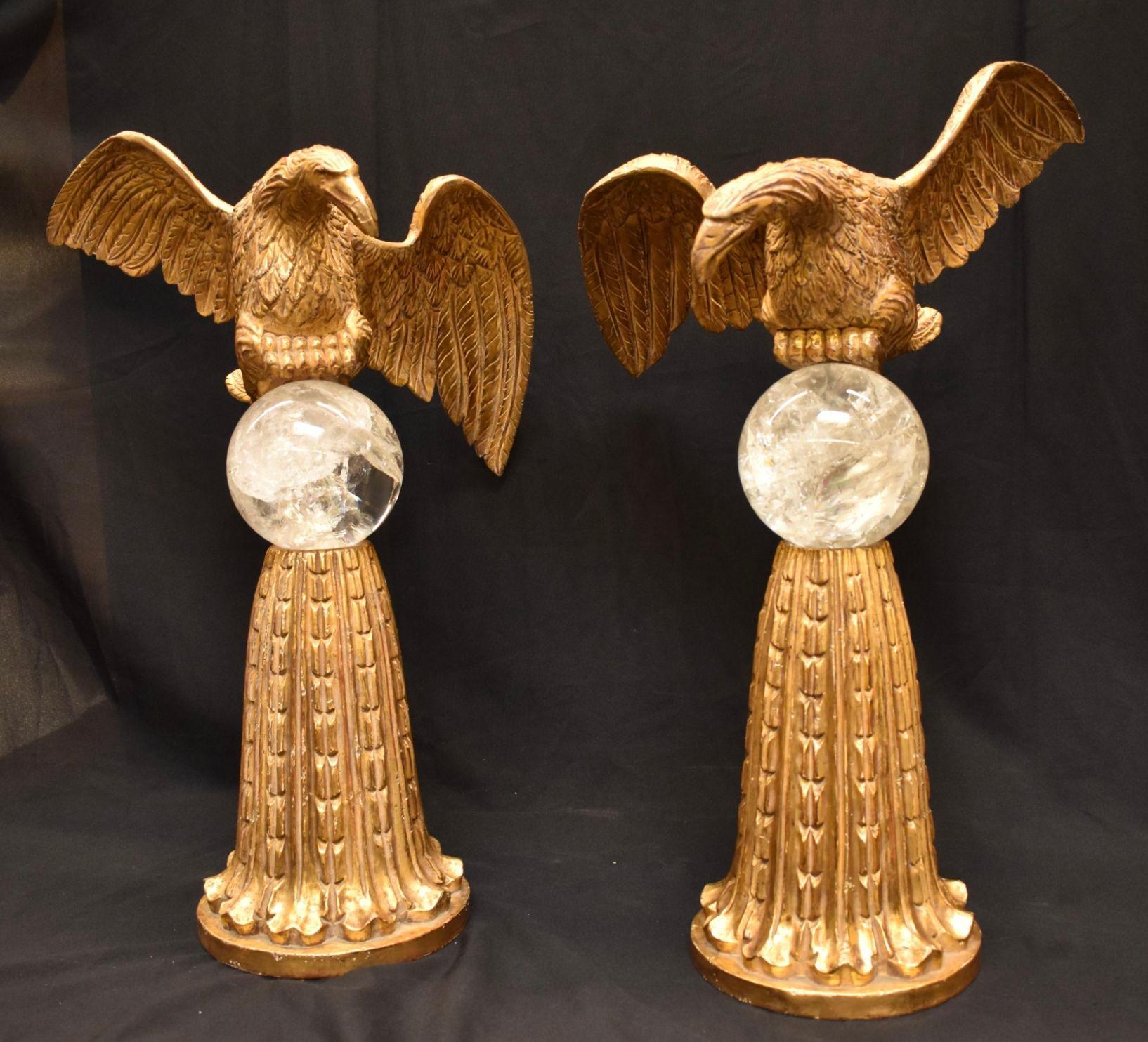 Paire de sculptures en bois sculptées à la main et dorées à l'eau, représentant un aigle, tenant chacune une sphère en cristal de roche et reposant sur des bases en bois doré avec un motif d'acanthe sculpté. Fabriqué aux États-Unis, fin du XXe