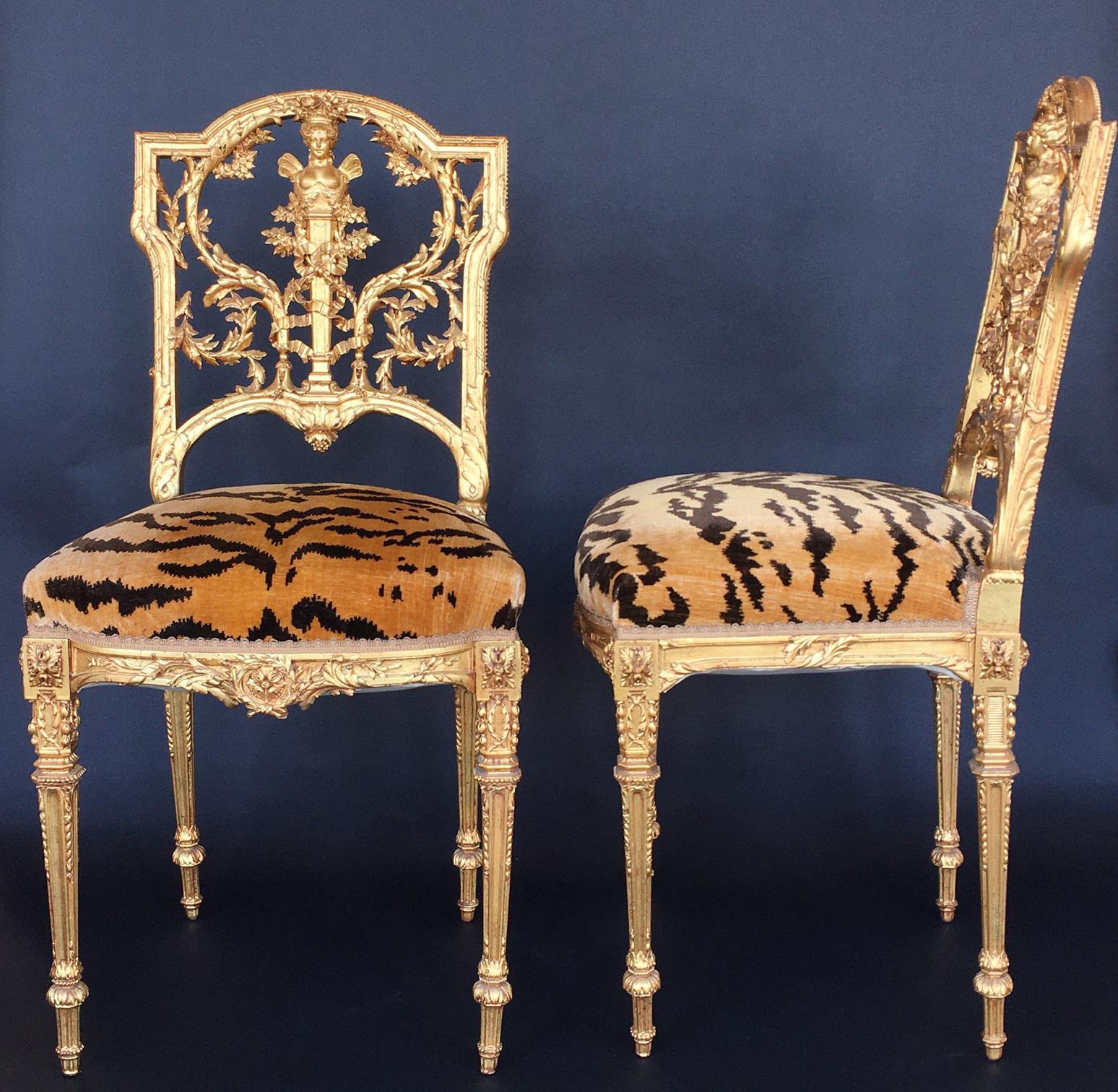Pair of detailed hand carved giltwood chairs with tiger upholstery.