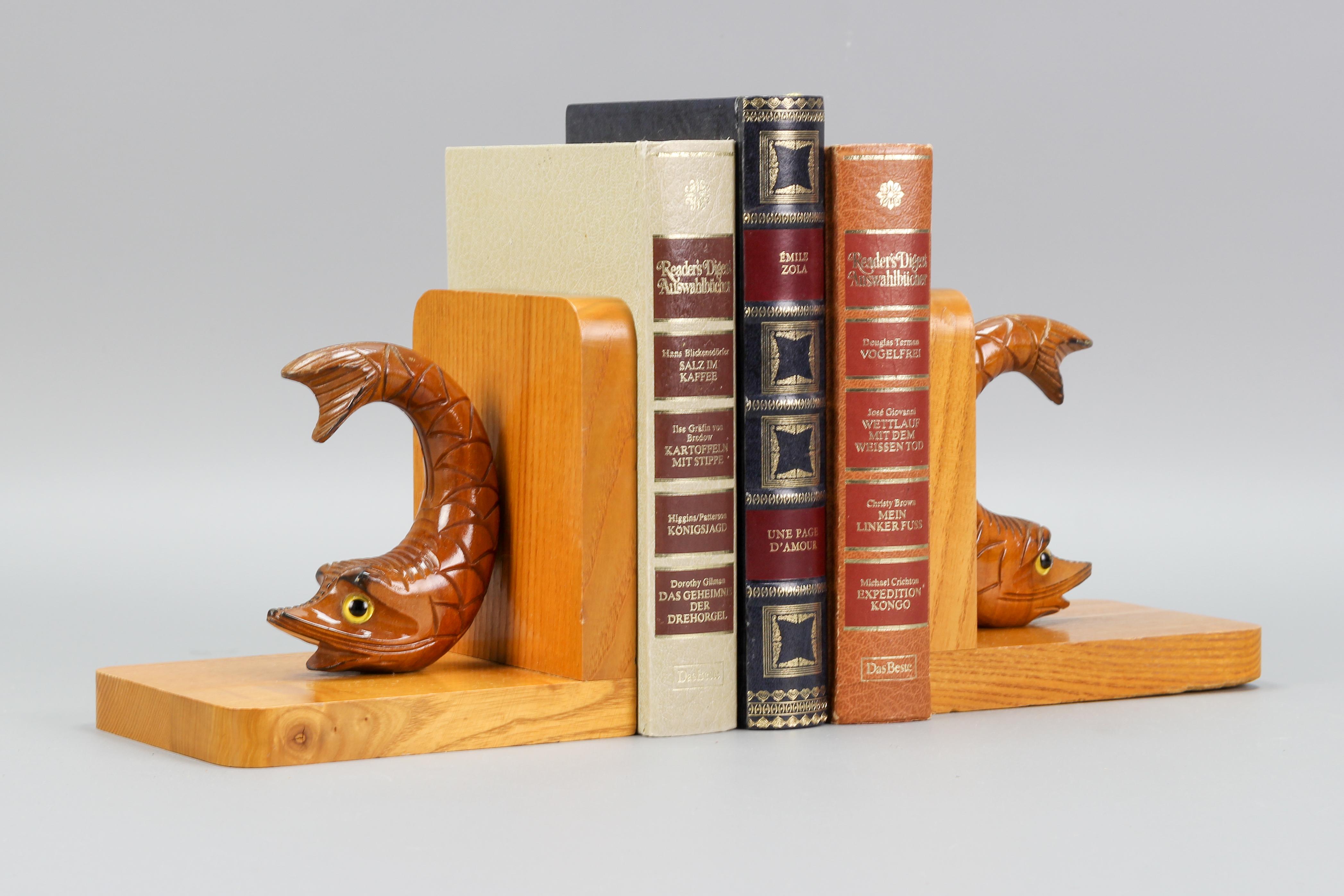 A charming pair of ash wood bookends with carved figurines of sturgeons with beautiful yellow and black eyes. Germany, circa the 1970s.
These adorable bookends will make a wonderful accent on a bookshelf, mantel, or console table. Ideal gift for