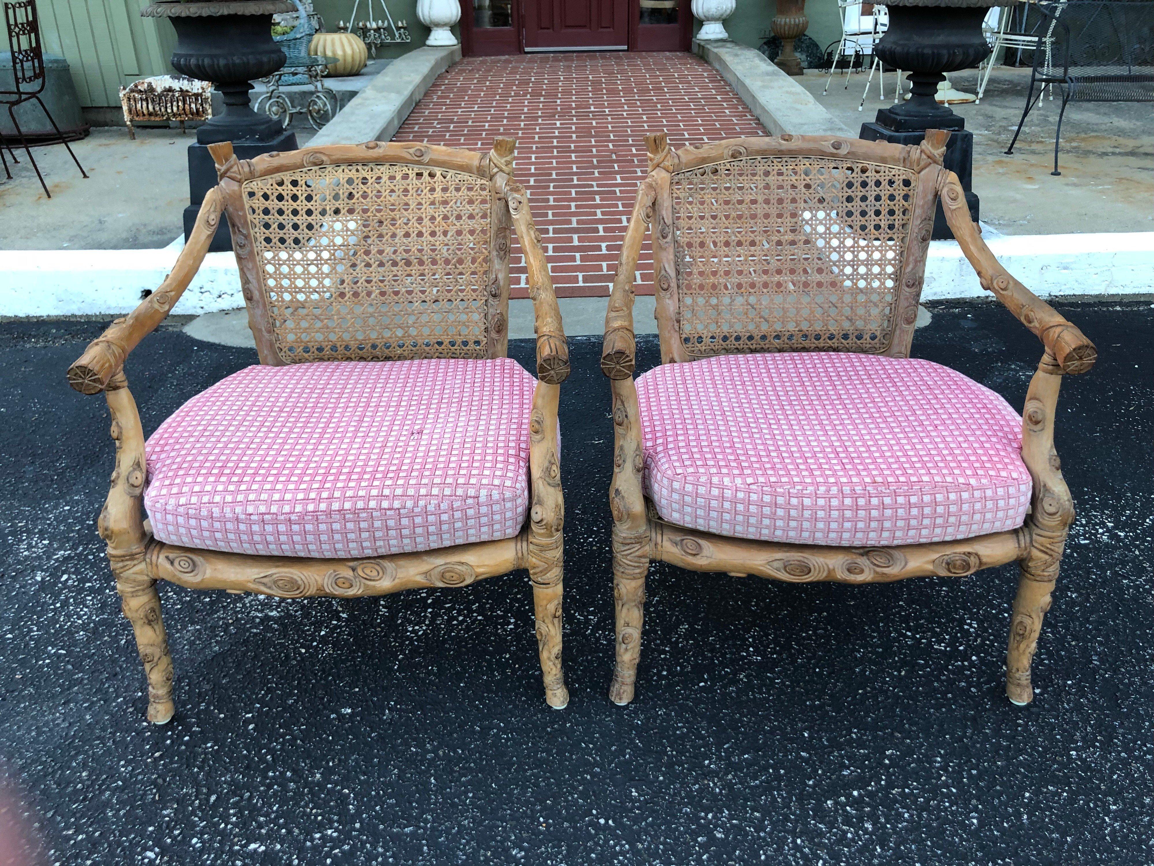 Pair of hand carved wooden faux bois armchairs. Solid wood, hand carved. Loose cushions can be removed or recovered. Small piece of wood missing in upper corner of left chair where arm meets the back. It is currently being repaired. Some breaks to