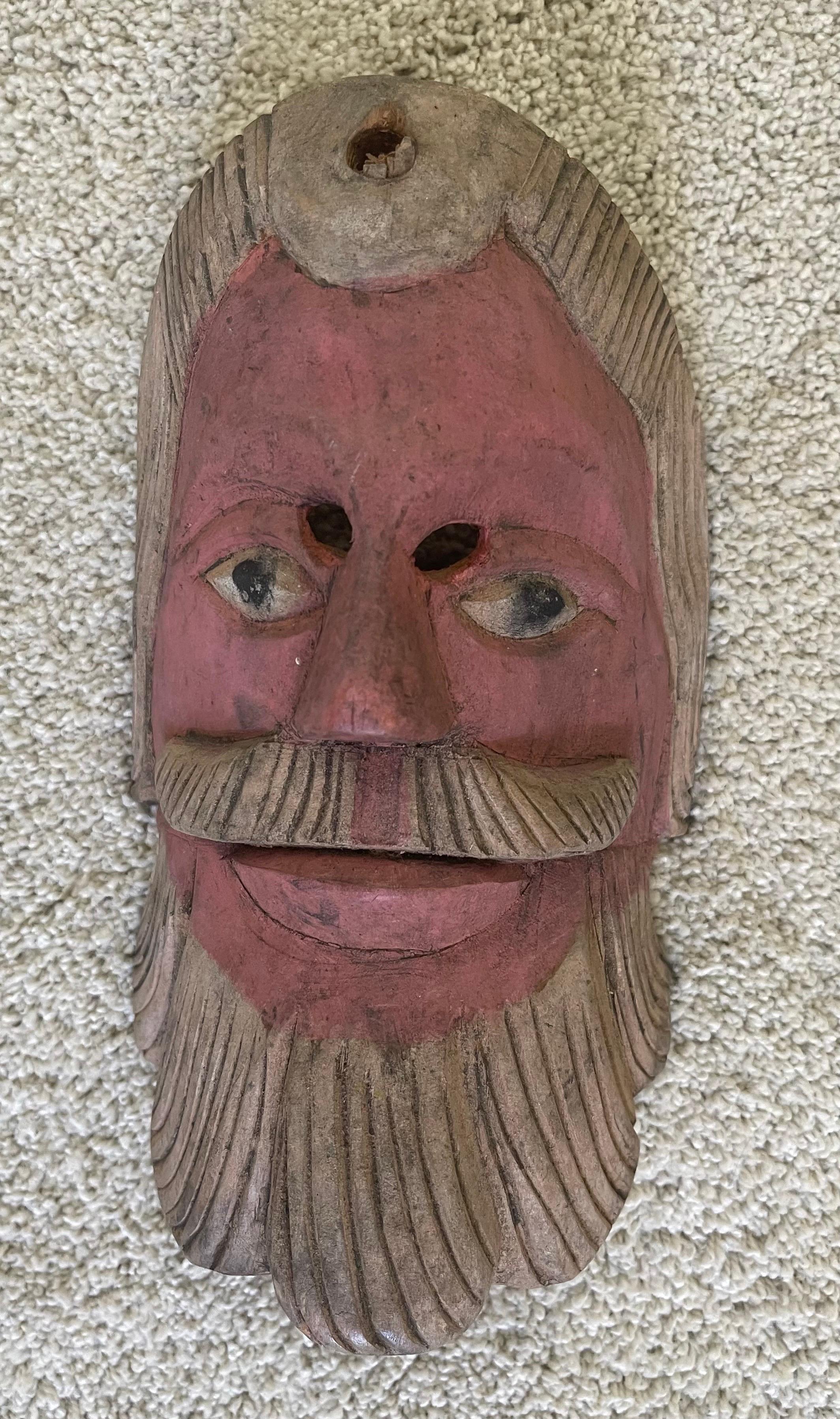 A very fun pair of hand carved wooden folk art masks circa 1940s. The set is in very good vintage condition and has a hanger on the reverse side; the larger mask measures 6.5