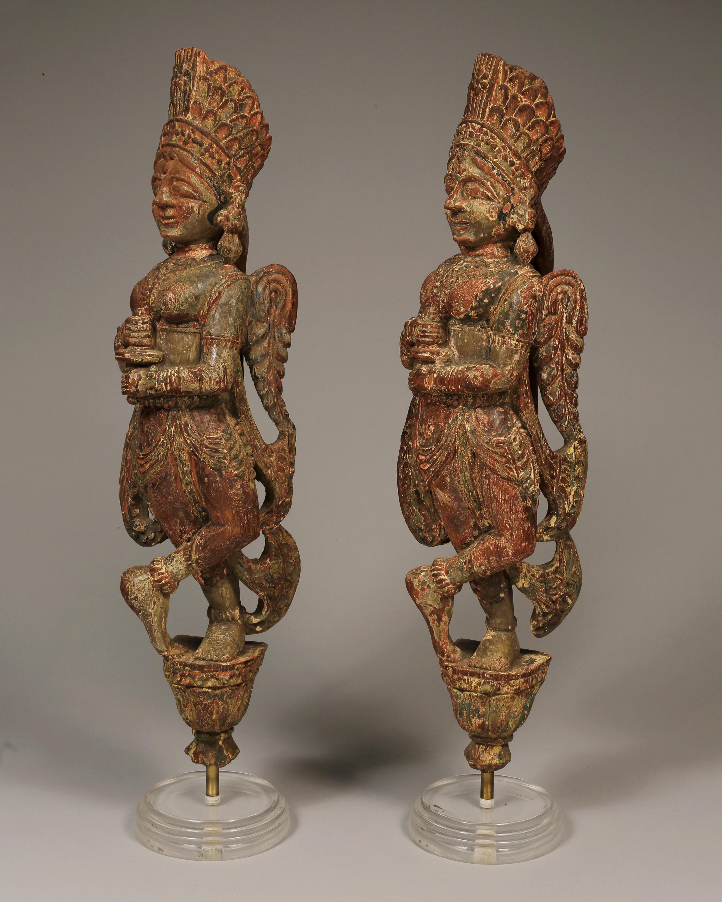 Pair of hand-carved wooden Chariot Angels from Gujarat, Rajasthan, 18th/19th century. 
Original polychrome colors. 

Topped with a tall headdress, the winged angels are depicted wearing earrings, necklaces and dresses. With arms holding an object