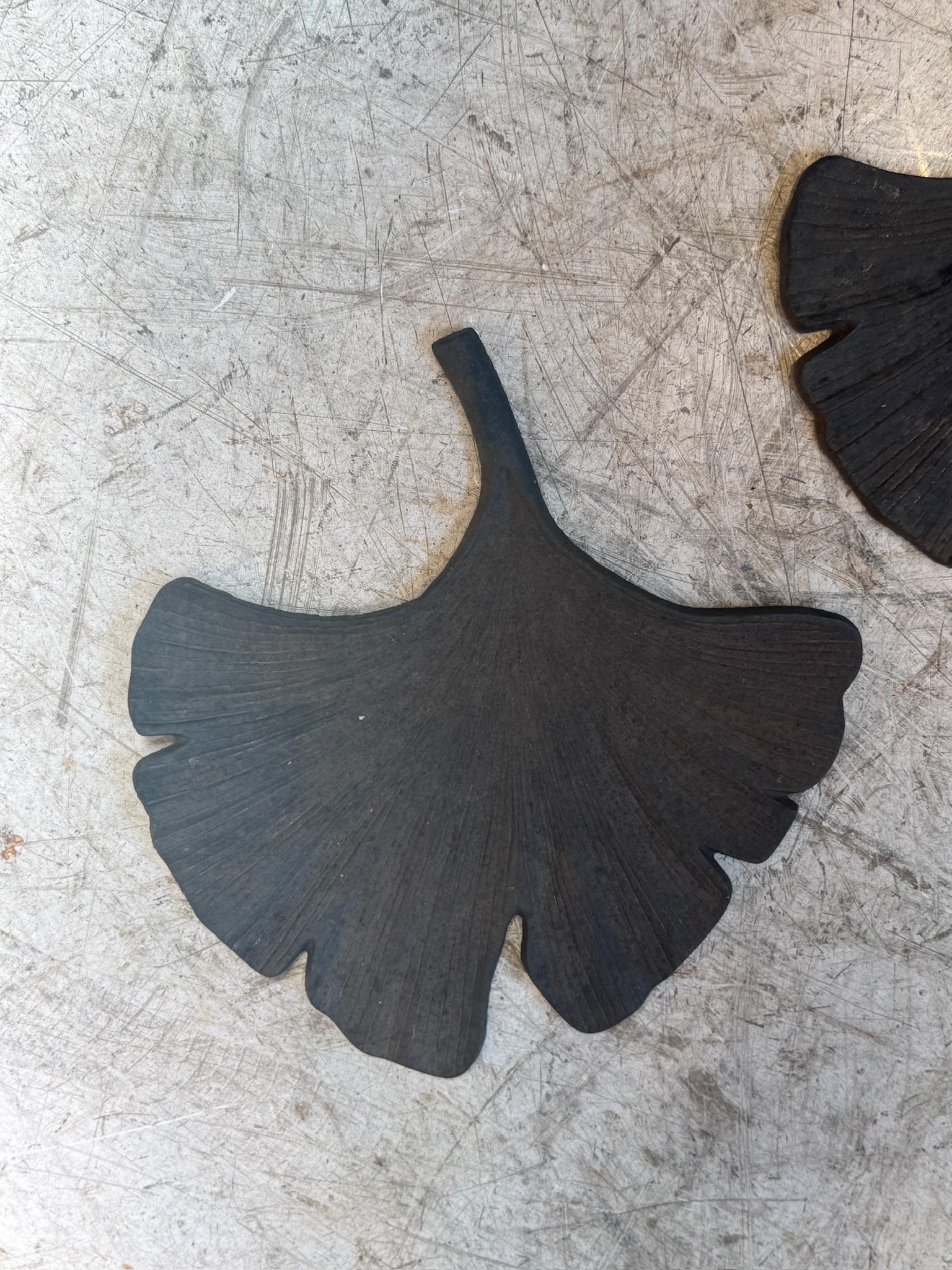 Dieses unverwechselbare Paar von Metallskulpturen fängt die fließenden, organischen Formen von Palmenblättern in einer stilisierten, abstrakten botanischen Form ein. Jedes Stück wird einzeln von Hand aus massivem Stahl geschnitten und mit einer